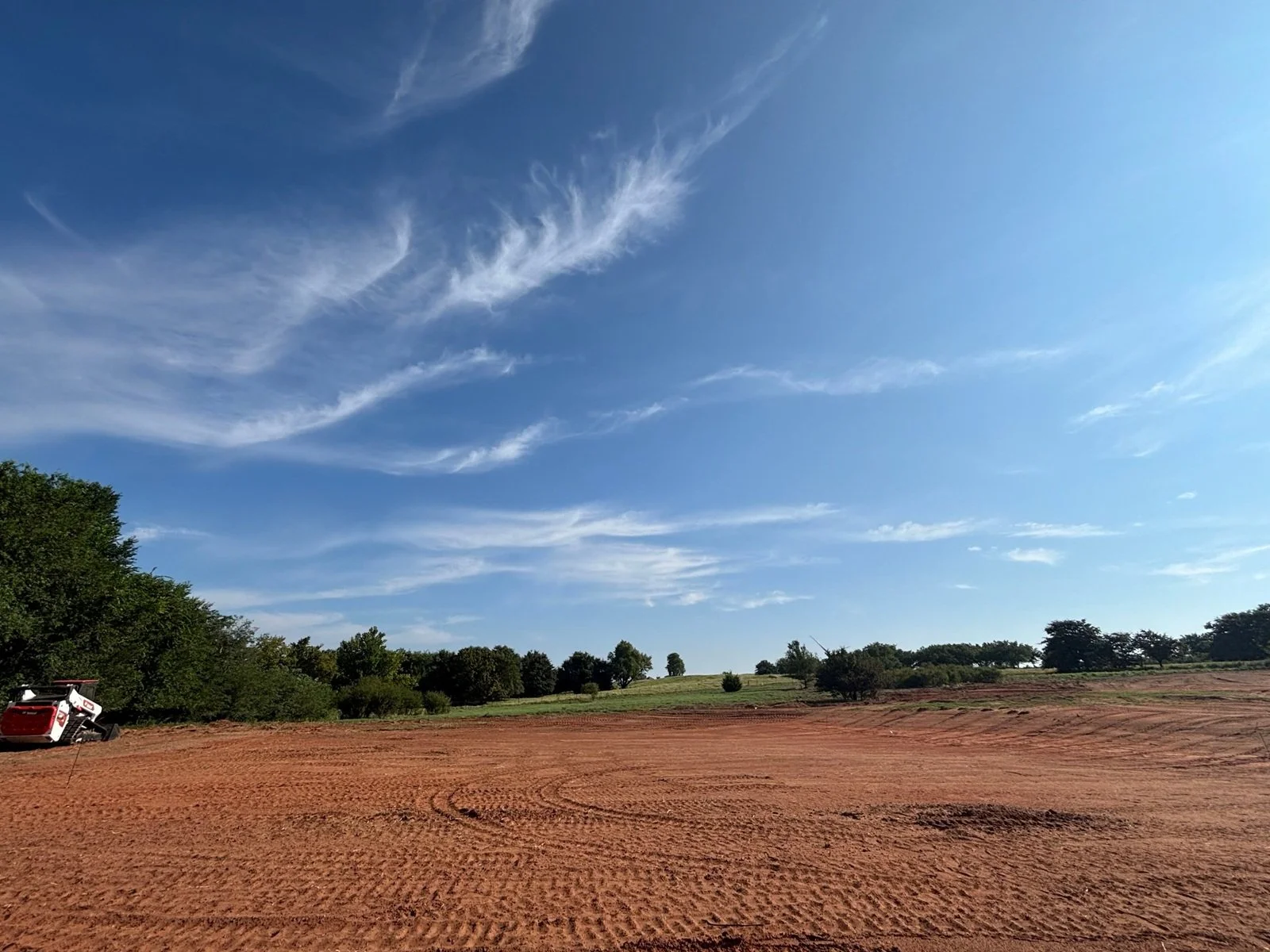 Cleared and graded home site with red dirt pad prepared by Barrett Land Services near Oklahoma City