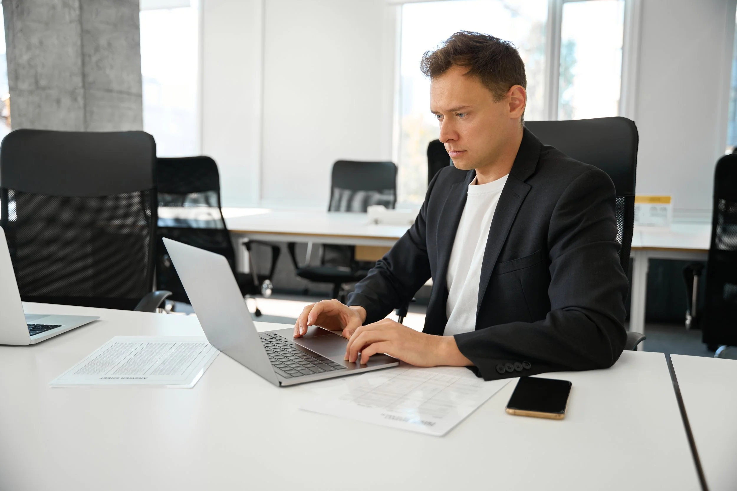 Businessman typing on laptop in office setting