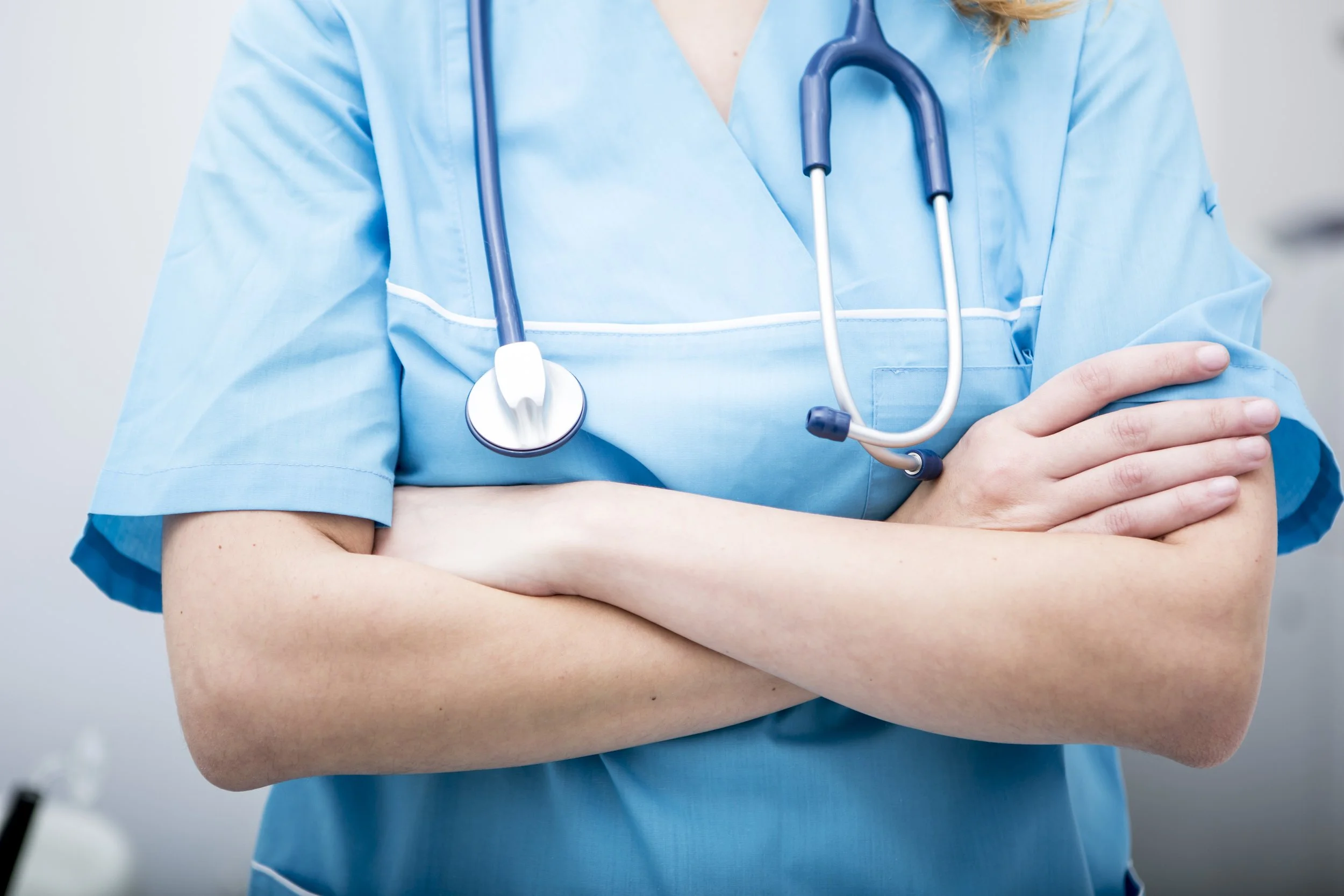 Closeup of nurse with her arms crossed.