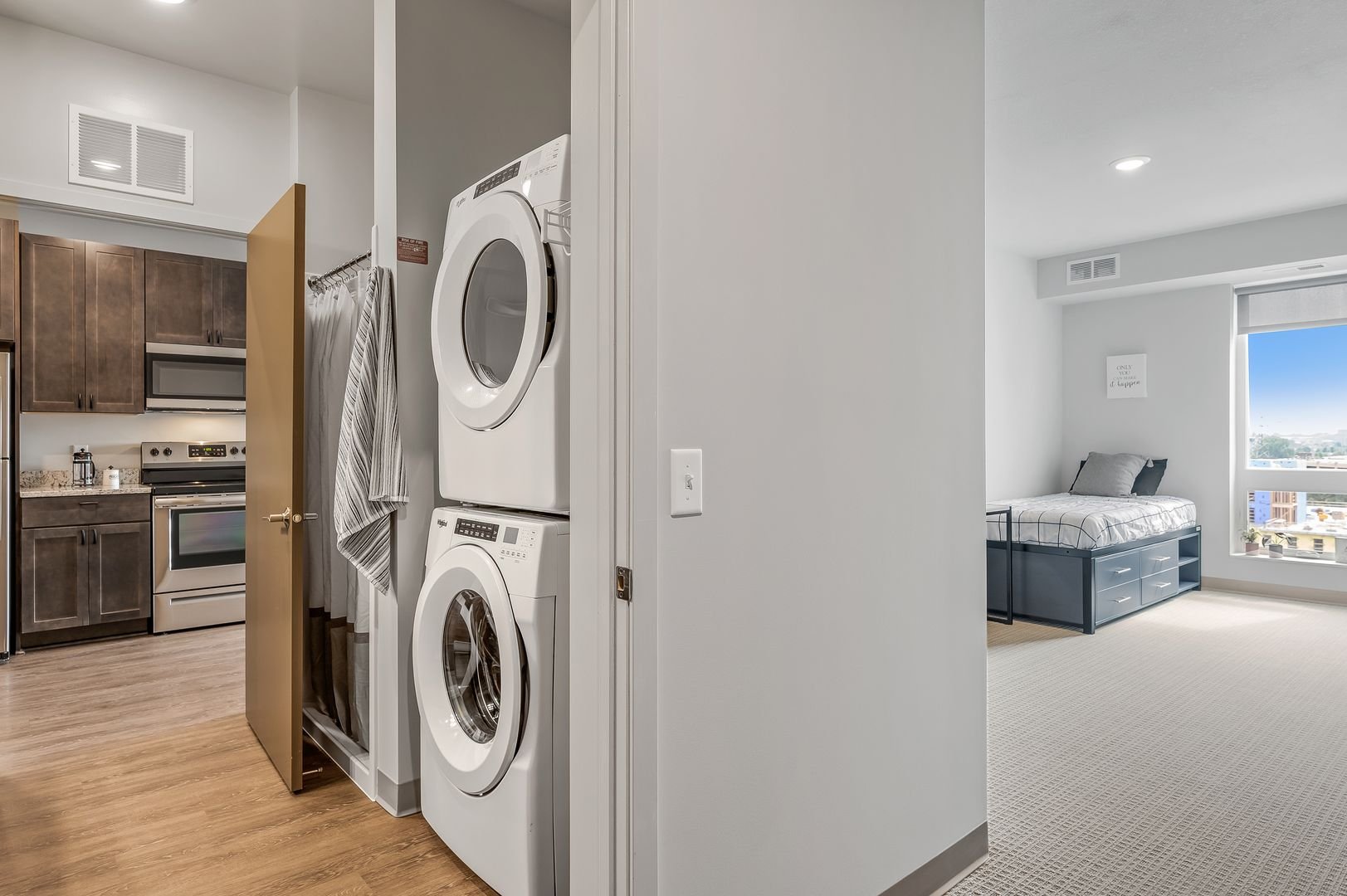 In-unit laundry area with stacked washer and dryer.