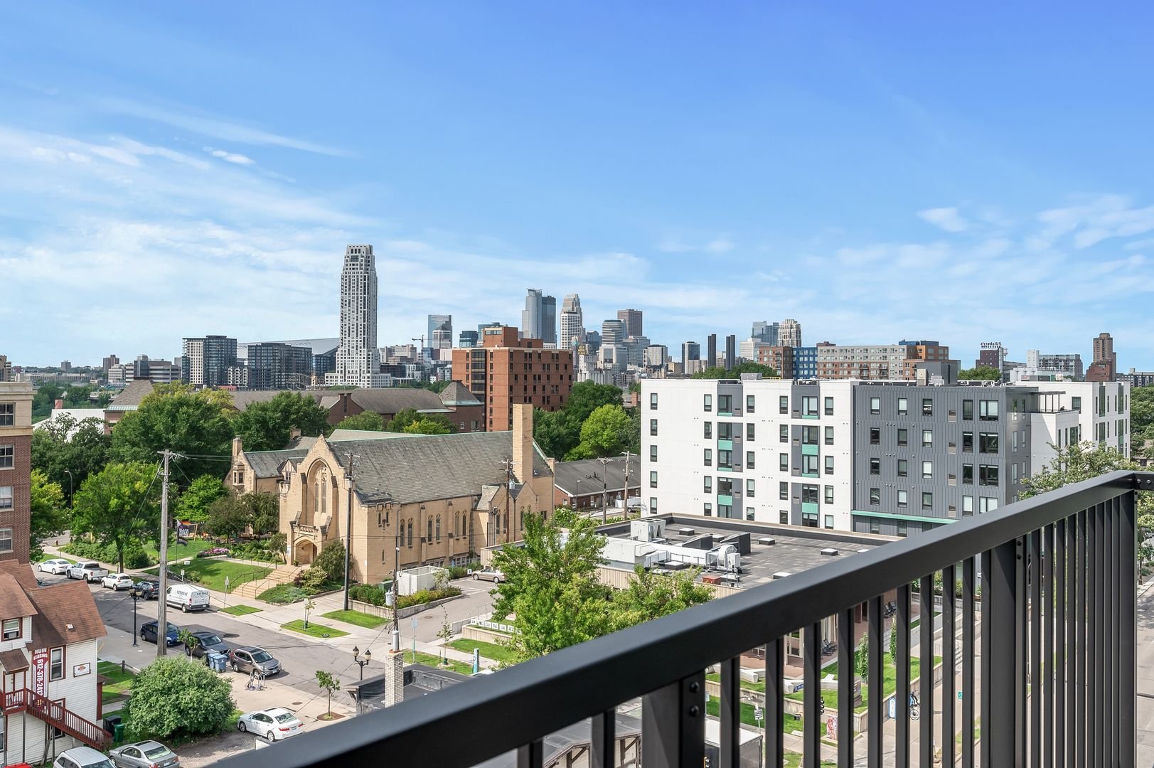 Dinkytown skyline view from a balcony with a black railing.