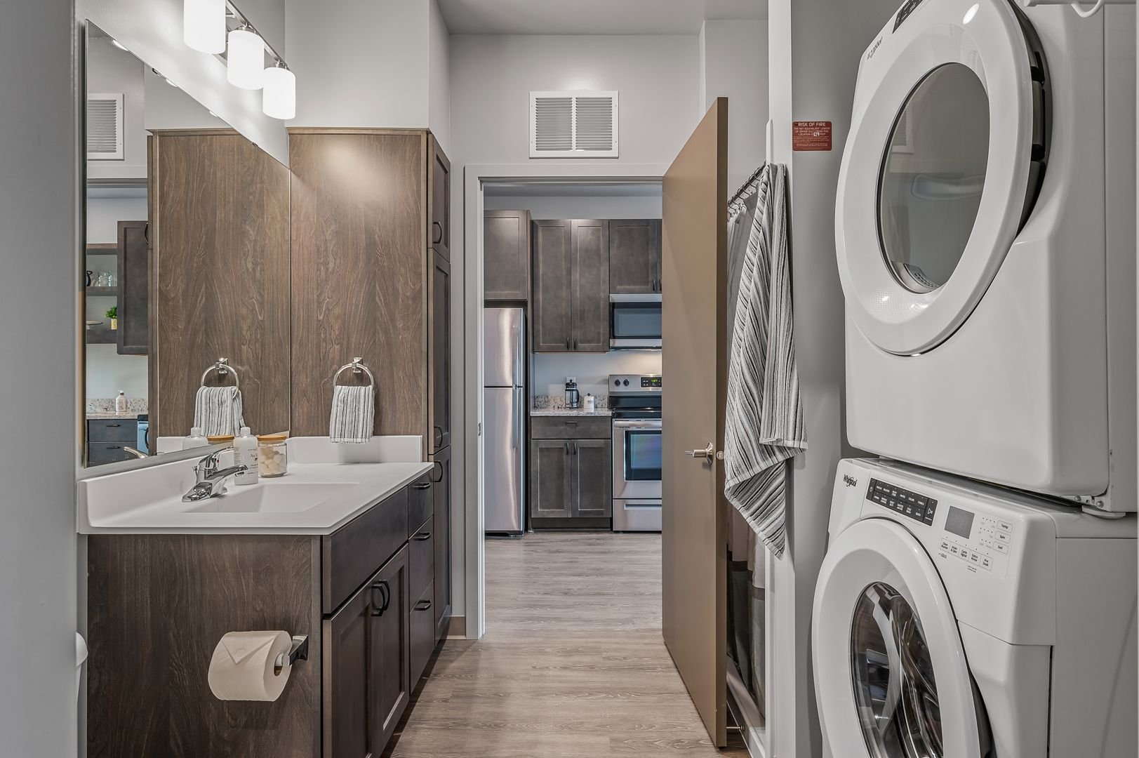 In-unit laundry with stacked washer and dryer in bathroom.