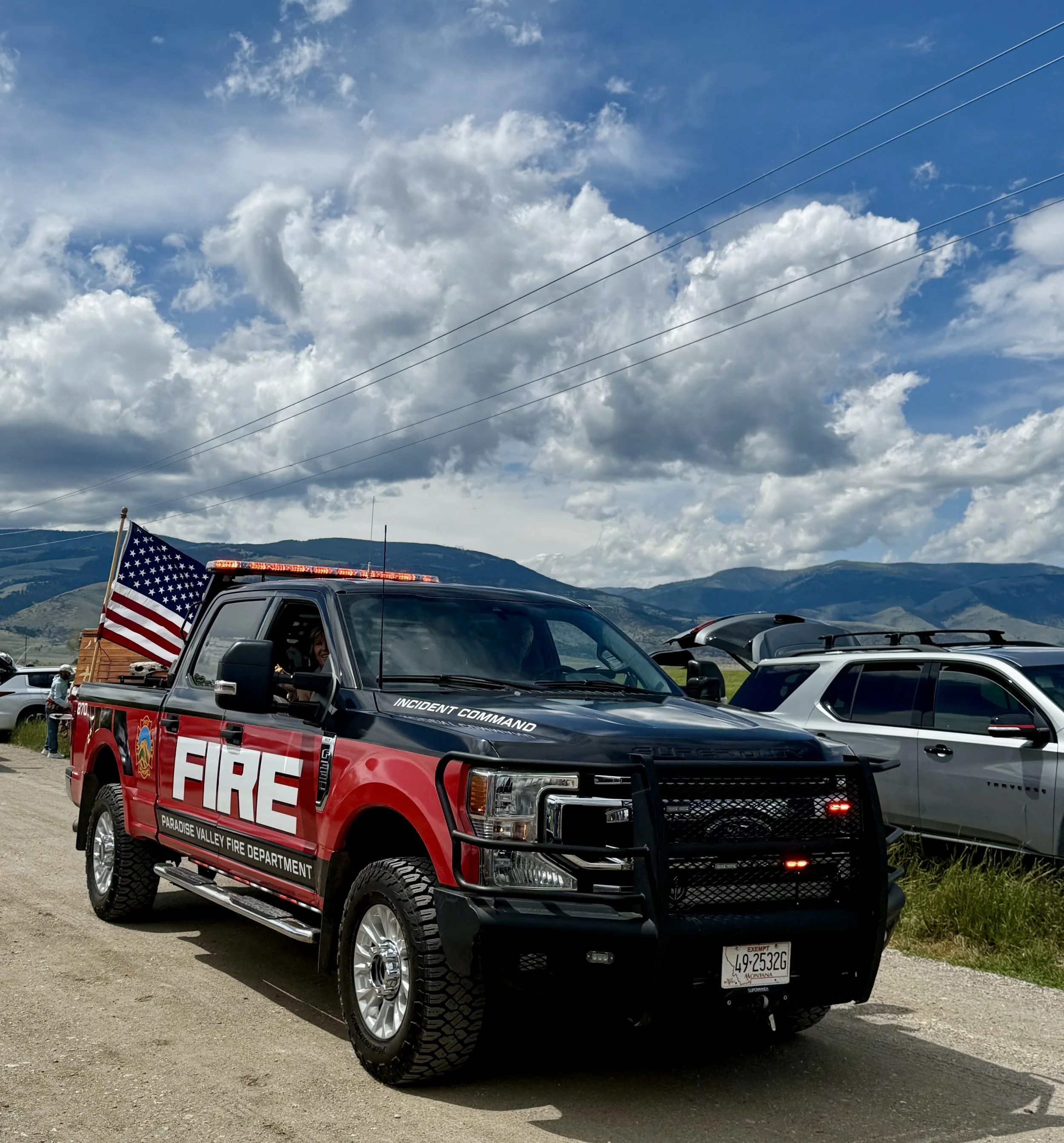 Fire department truck from Paradise Valley Fire Department with an American flag and mountains in the background.
