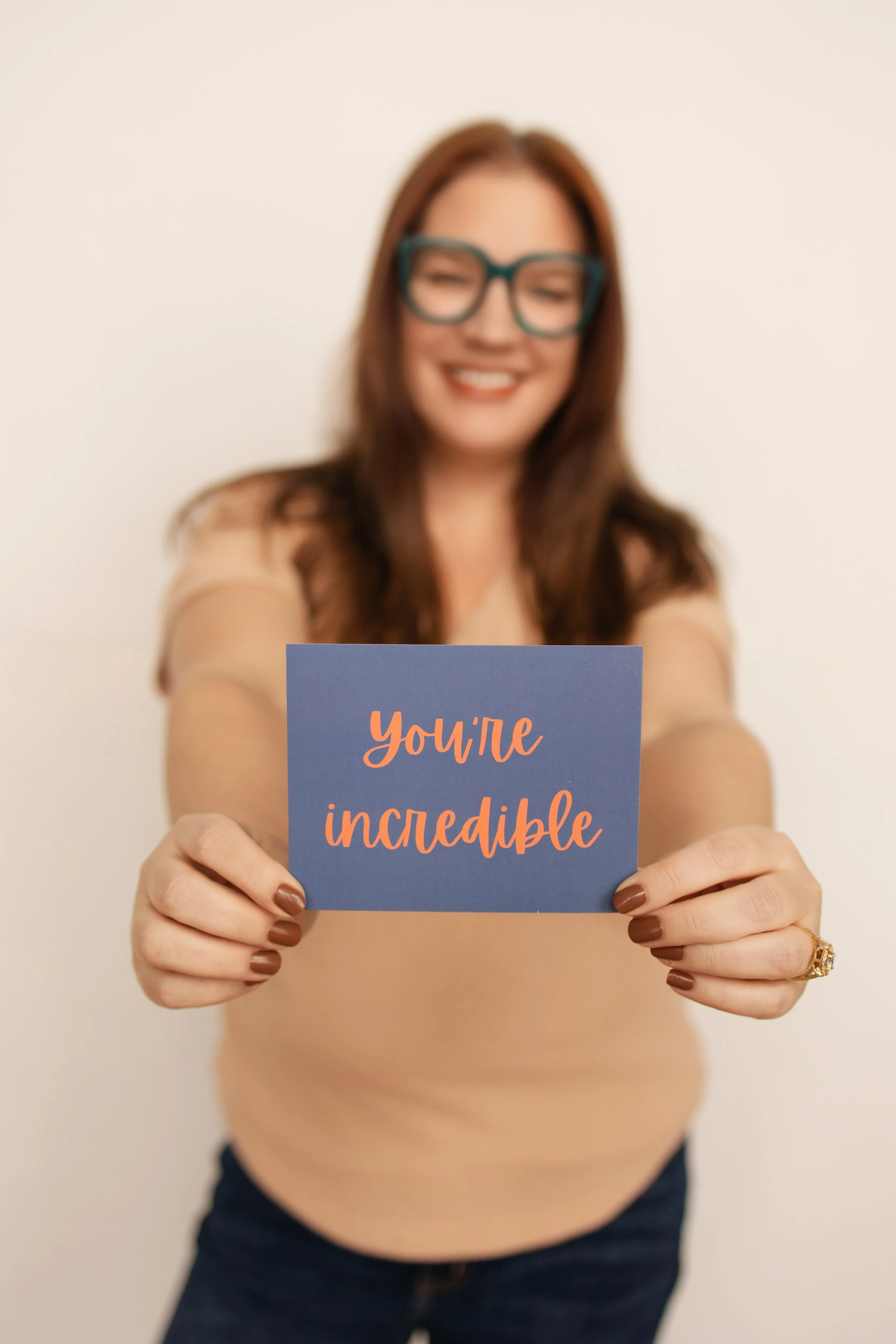 Founder of KAYDEE holds a card celebrating the success of their small business clients' success.