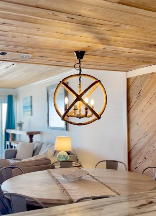 Wooden chandelier above a dining table in a Gulf Style Rentals home