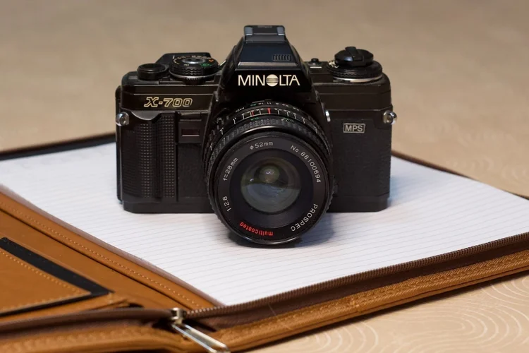 Film camera resting on a leather notebook