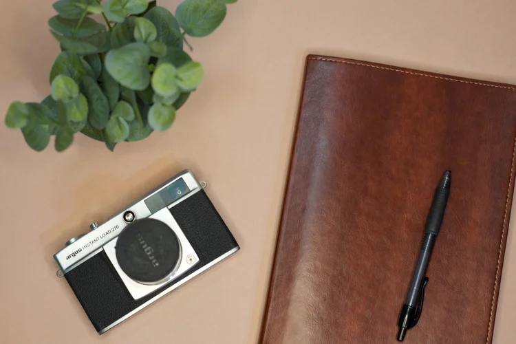 Vintage camera, pen and leather journal