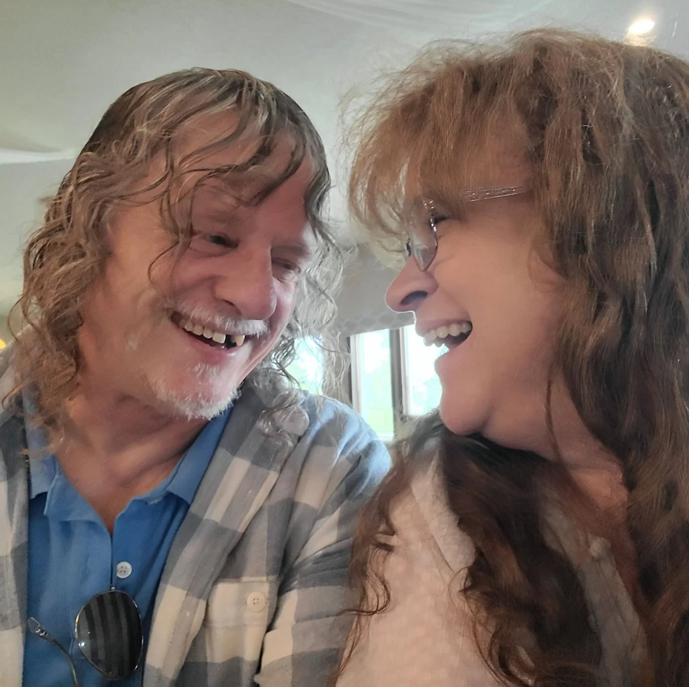 A man and woman sharing a happy moment, smiling and laughing while looking at each other.