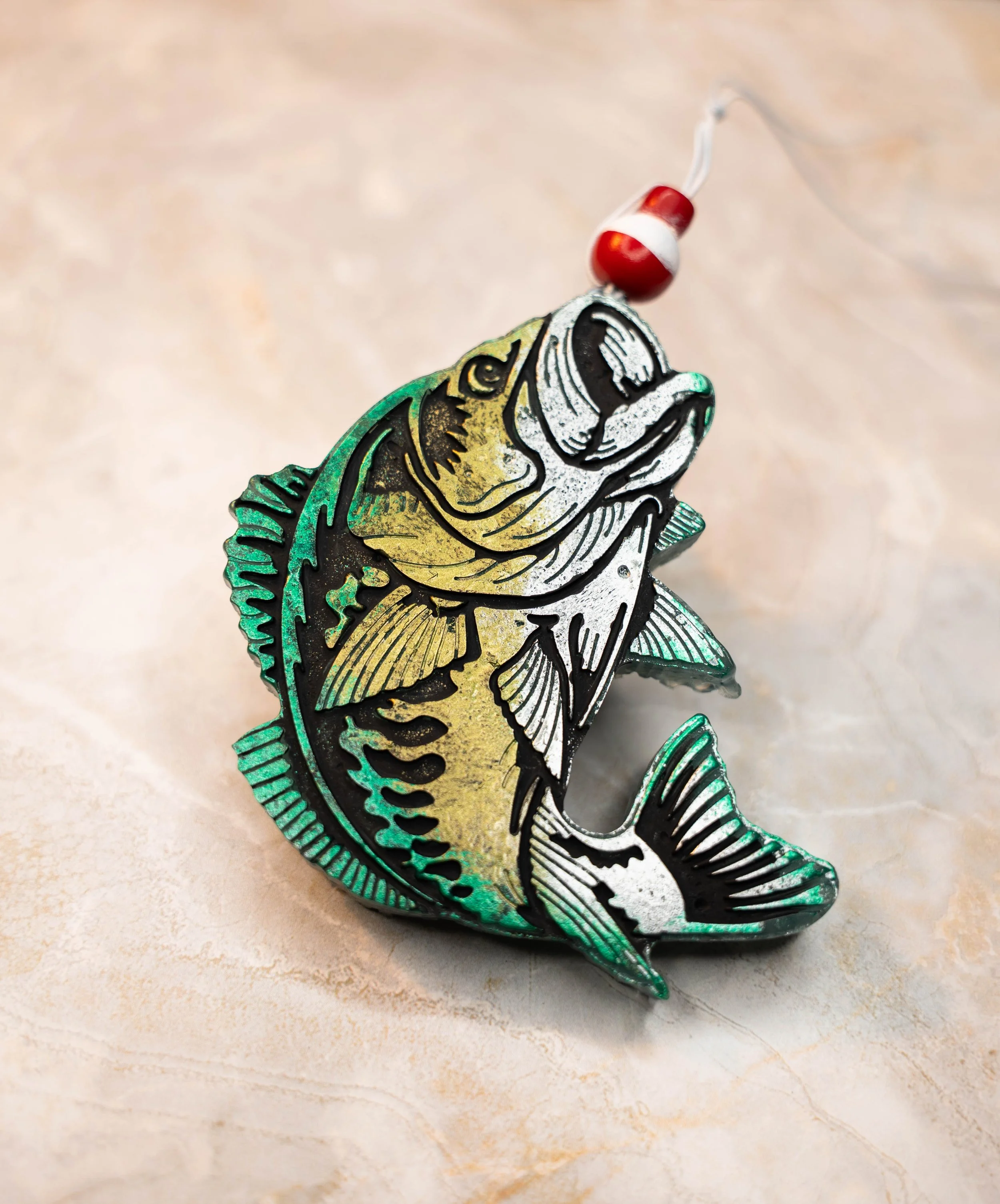 A colorful metallic fish-shaped fishing lure with a red and white bobber attached to a fishing line.