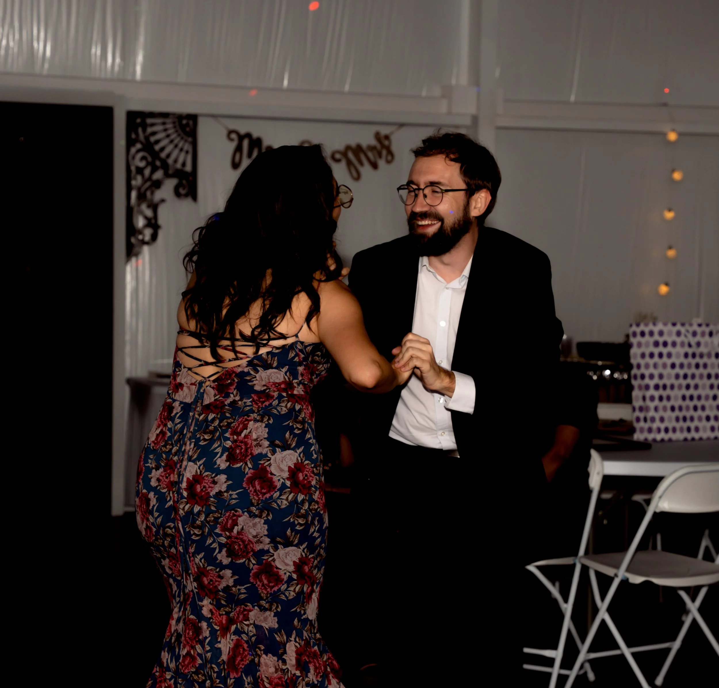 A man and woman dancing and smiling at a celebration or party.