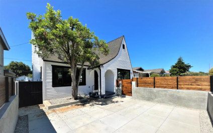 Whole-home exterior renovation with new siding, black-framed windows, paver hardscape and wood fencing in Los Angeles, California
