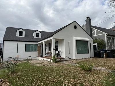 Renovated single-family home exterior with new roof, dormers, black-framed windows and covered porch in Glendale, California