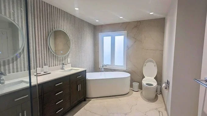Primary bathroom remodel with freestanding soaking tub, double vanity and marble-look porcelain tile in Glendale, California