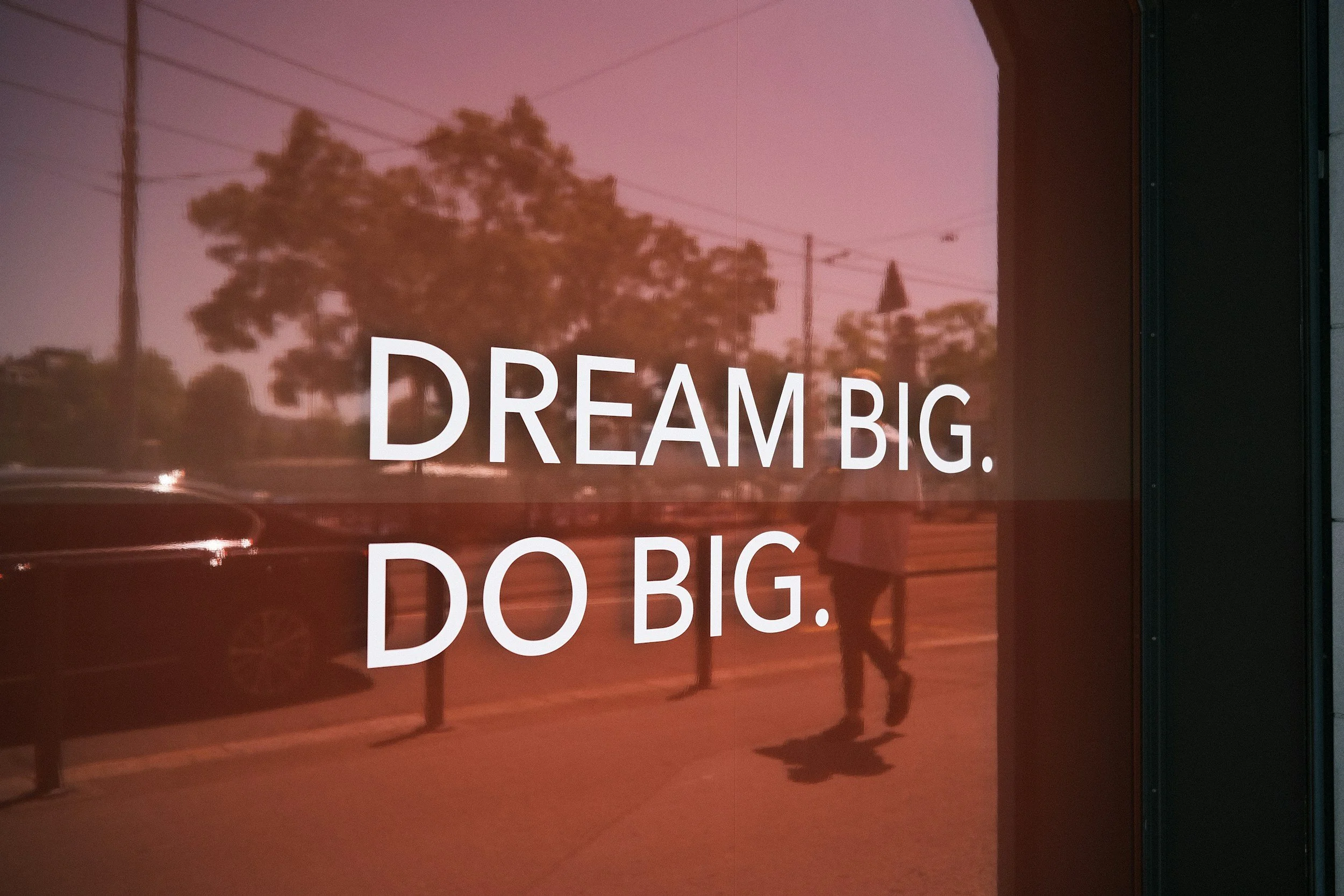 lettering on a window stating Dream Big. Do Big.