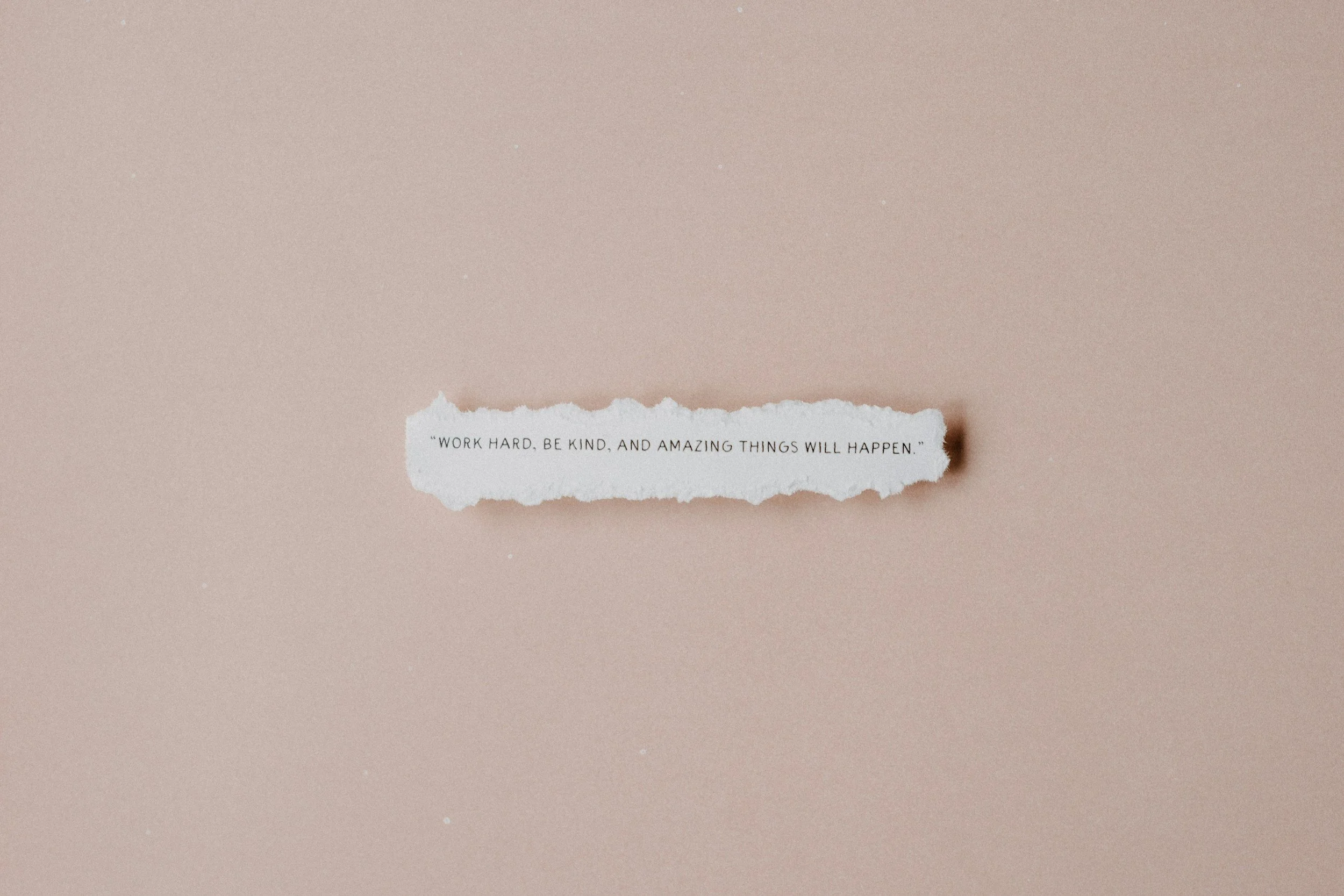 a small piece of paper that says work hard, be kind, and amazing things will happen