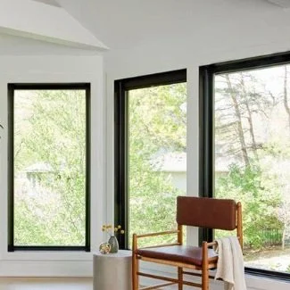 Sunny room with large windows, a wooden chair, and a small side table.