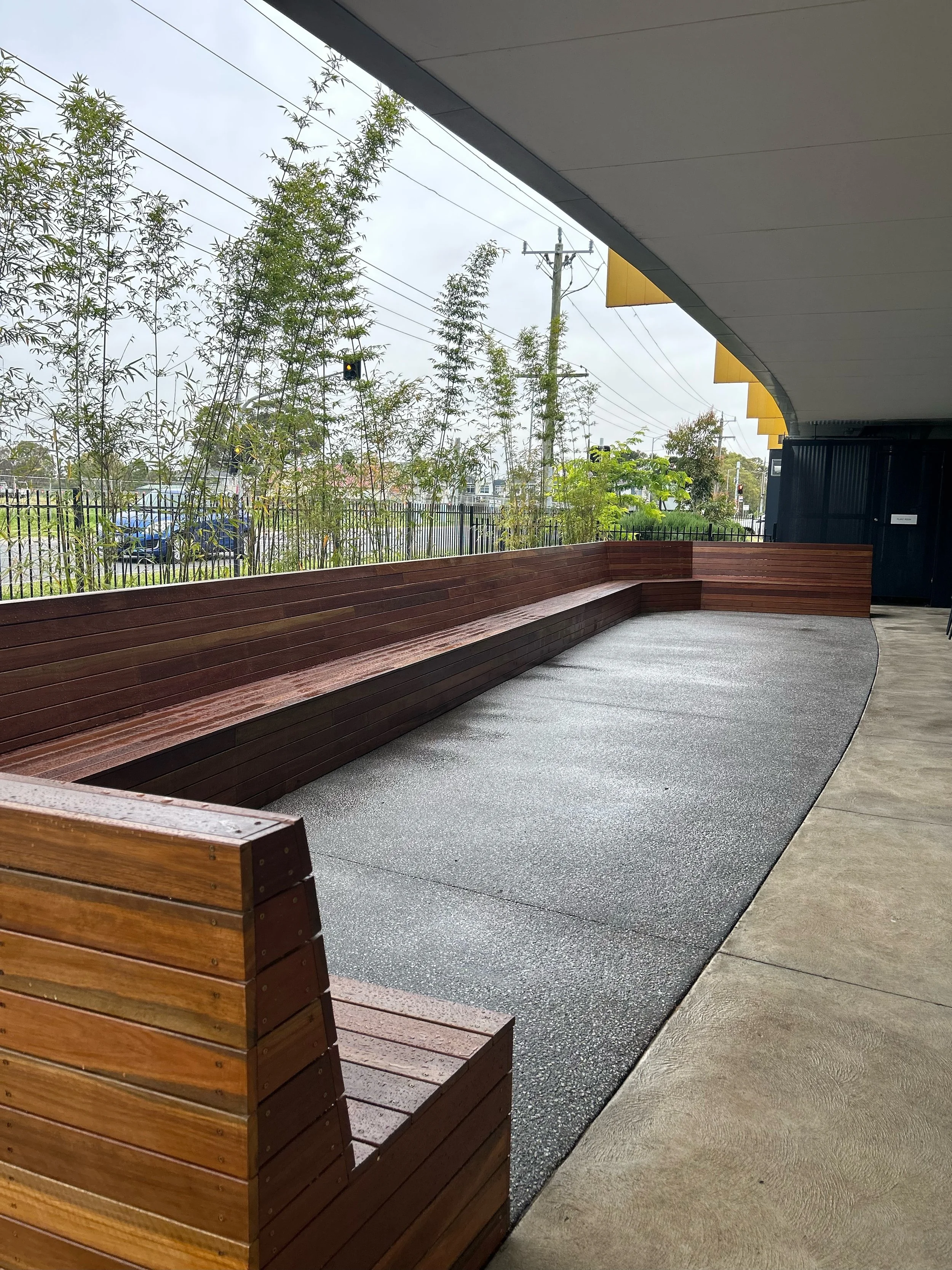 Staff courtyard primary school wooden bench seating construction, exposed aggregate concreting