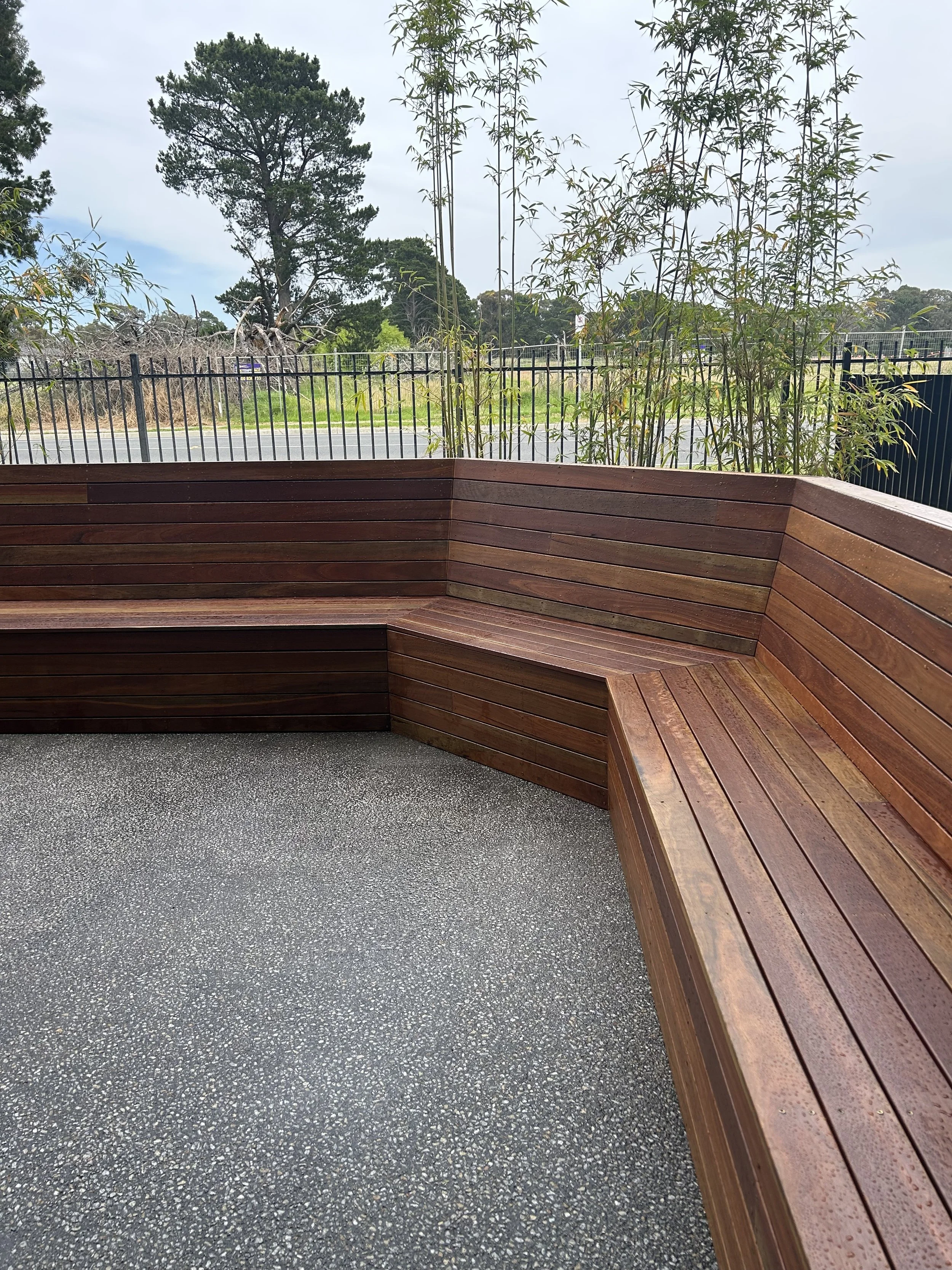 Staff courtyard primary school wooden bench seating construction, exposed aggregate concreting