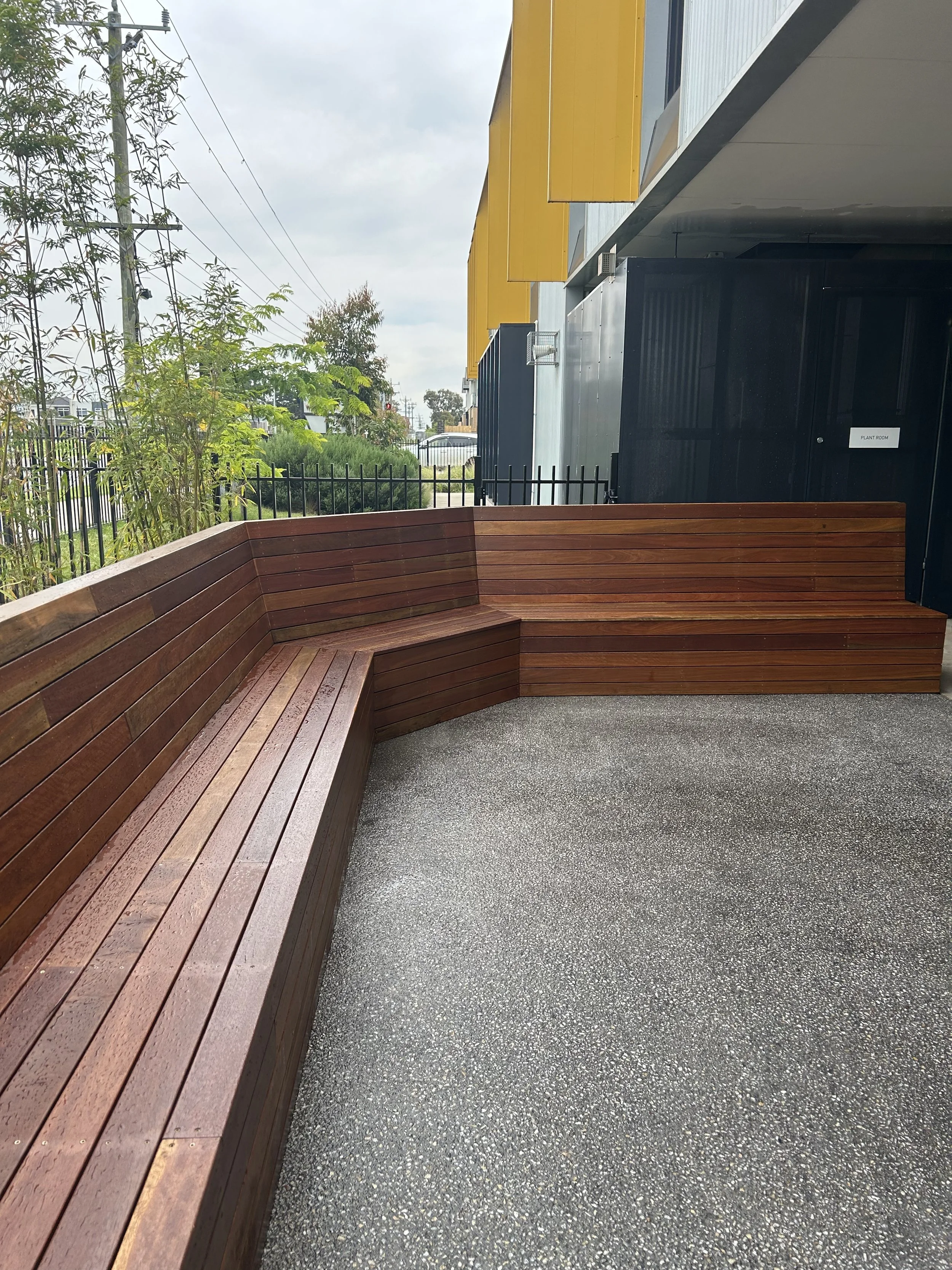 Staff courtyard primary school wooden bench seating construction, exposed aggregate concreting
