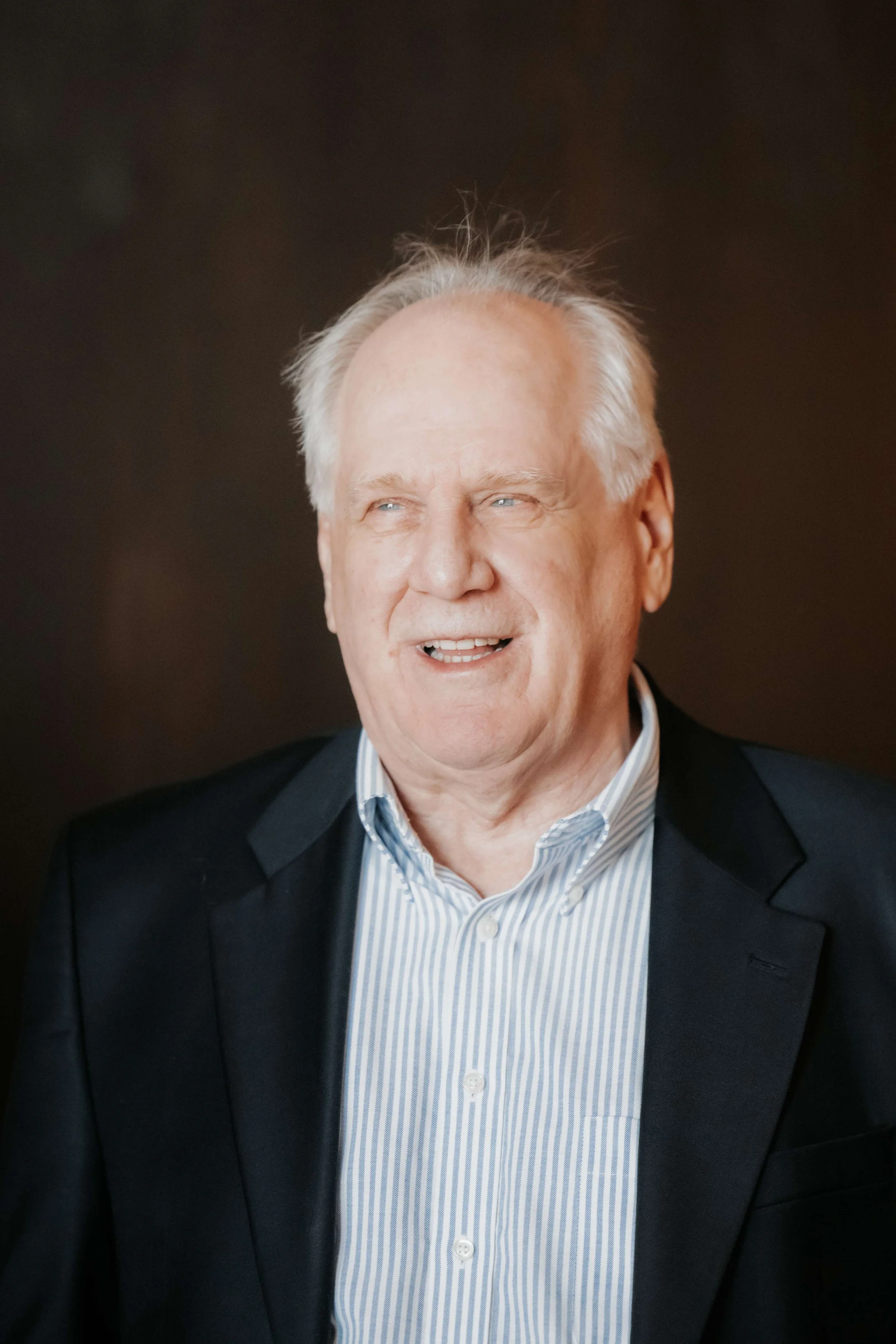 Dr. Solon in striped shirt and dark blazer smiling.