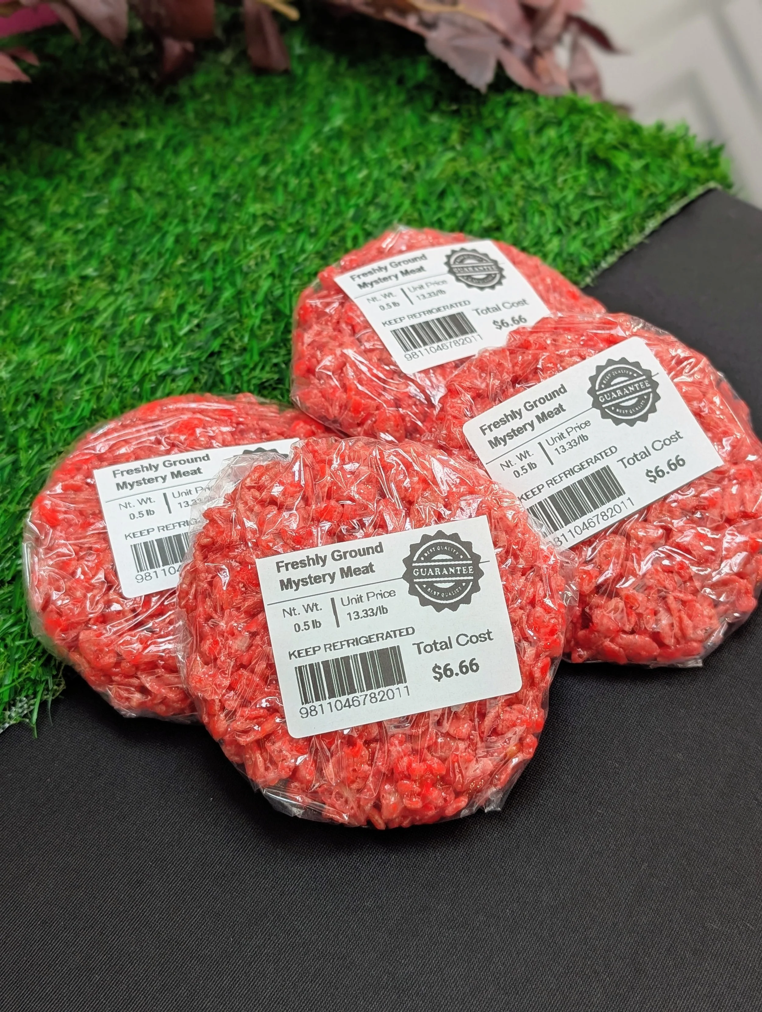 Novelty Halloween rice crispy treats dyed bright red to resemble raw ground meat patties, individually wrapped in plastic with "Freshly Ground Mystery Meat" grocery-style price tags.