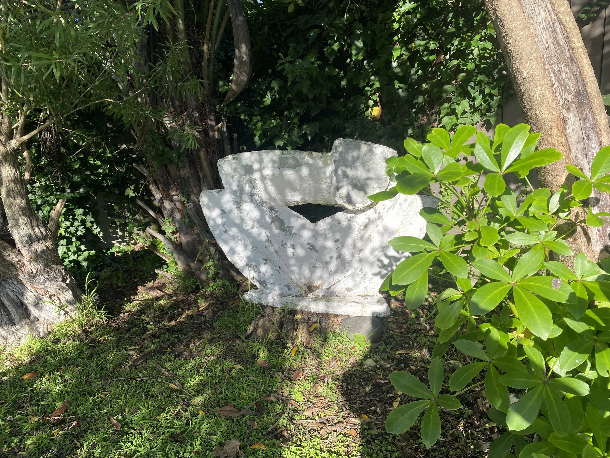 Dreaming limestone sculpture by Pan Theodosiou, garden setting, Kaipara Coast NZ