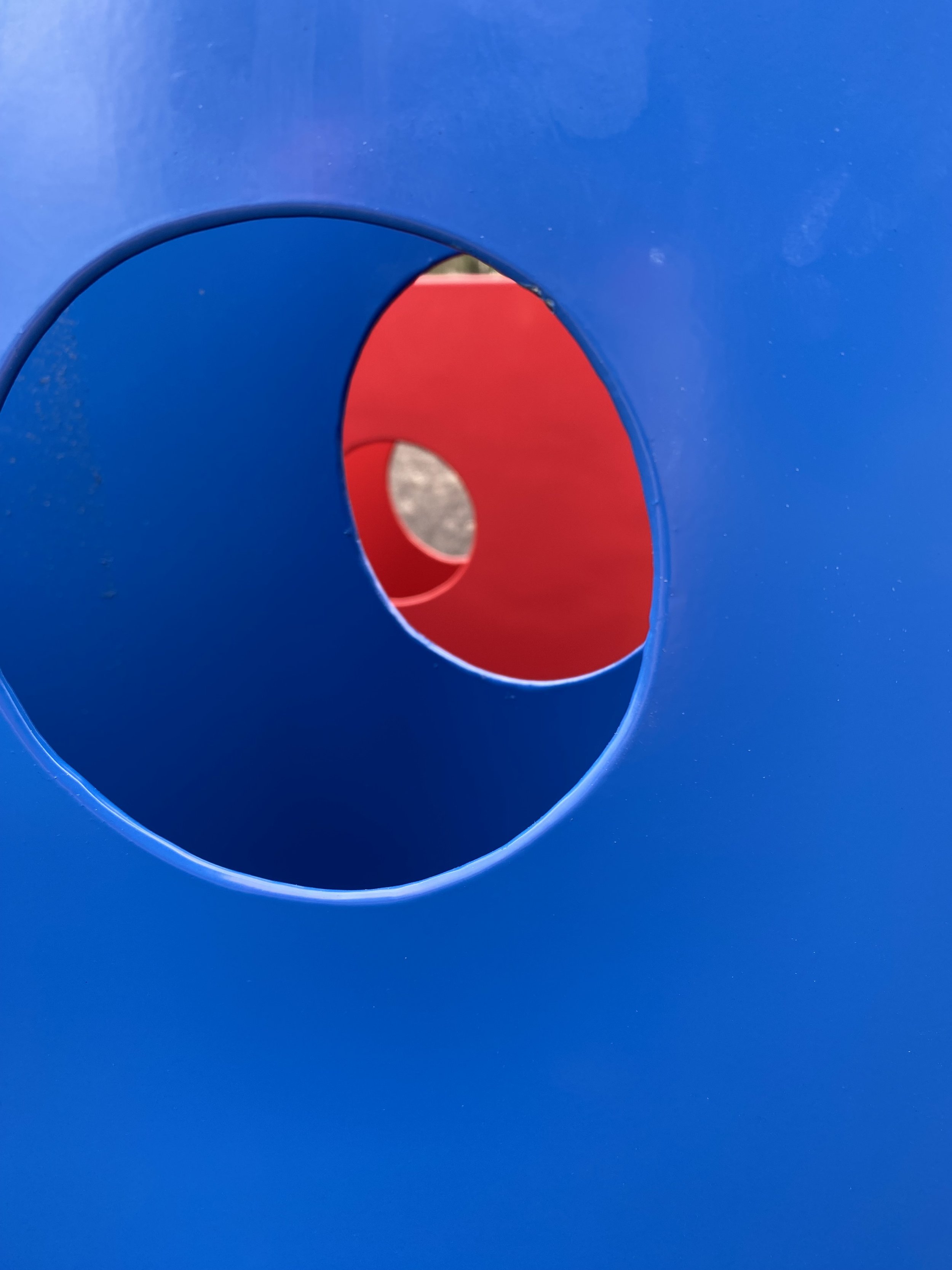 Blue and red playground equipment with circular cutouts