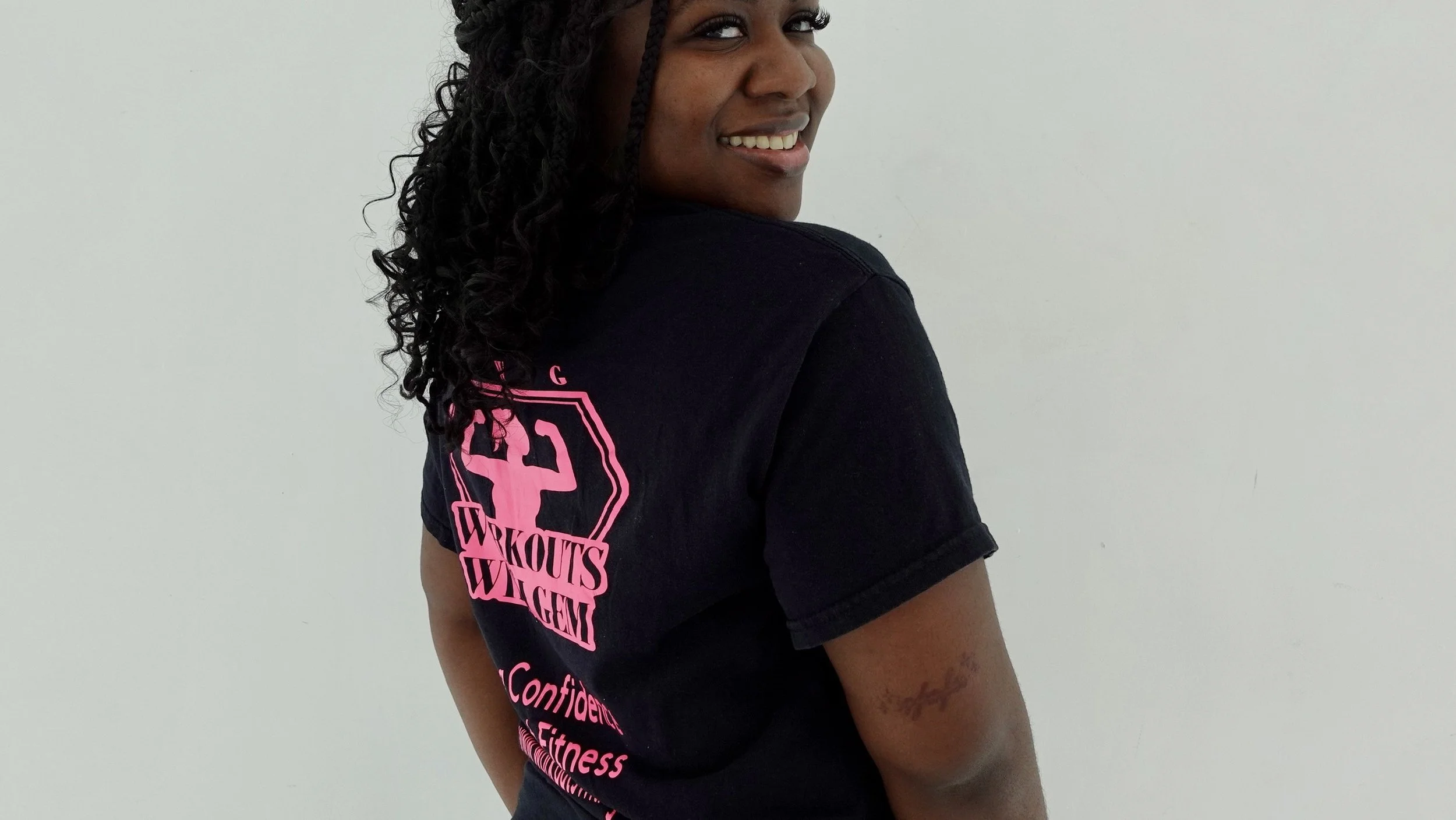 A smiling woman with black t-shirt looking back smiling.