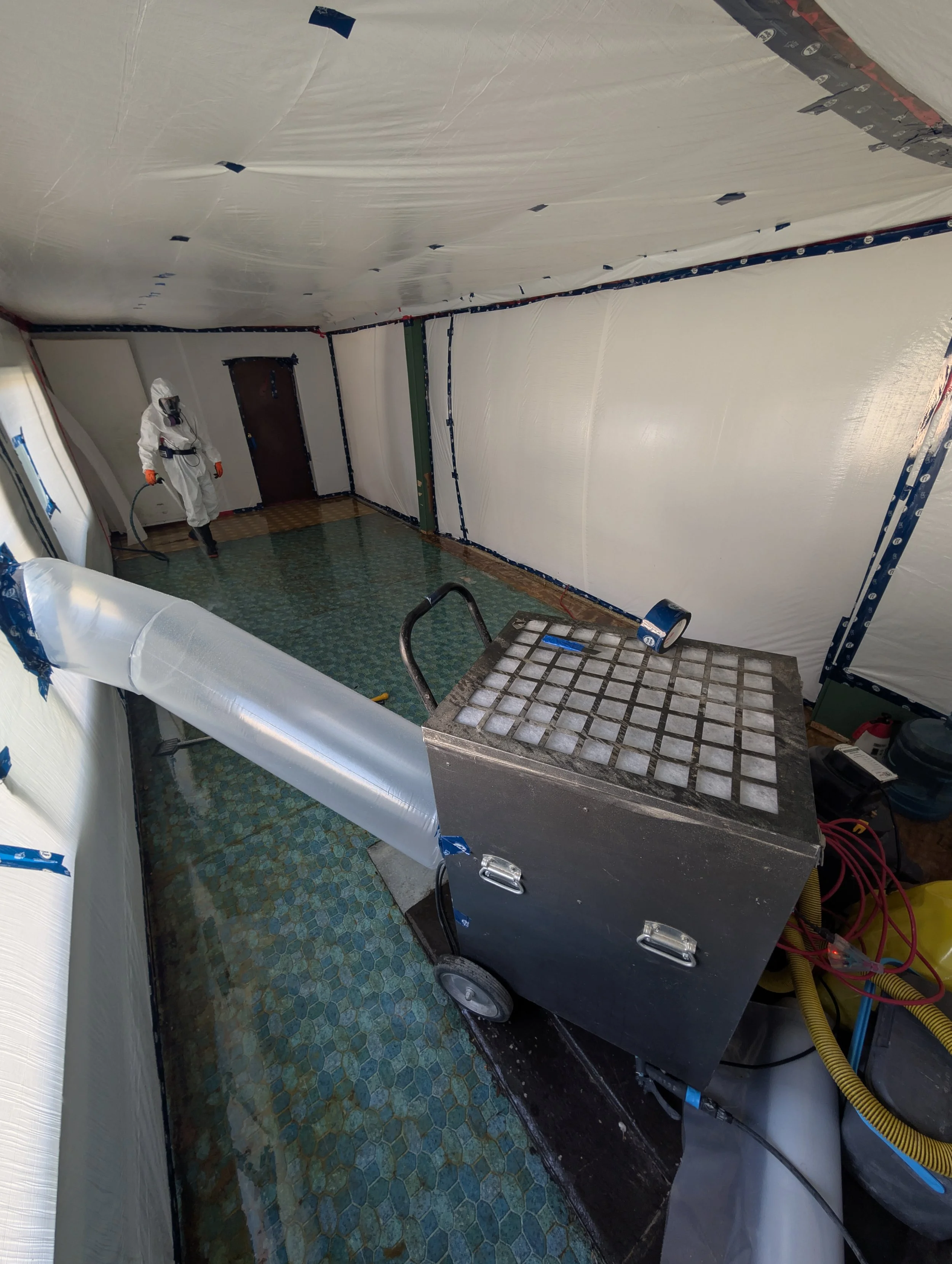 High-standard asbestos containment with negative air machine and HEPA filtration during removal in Kelowna BC.