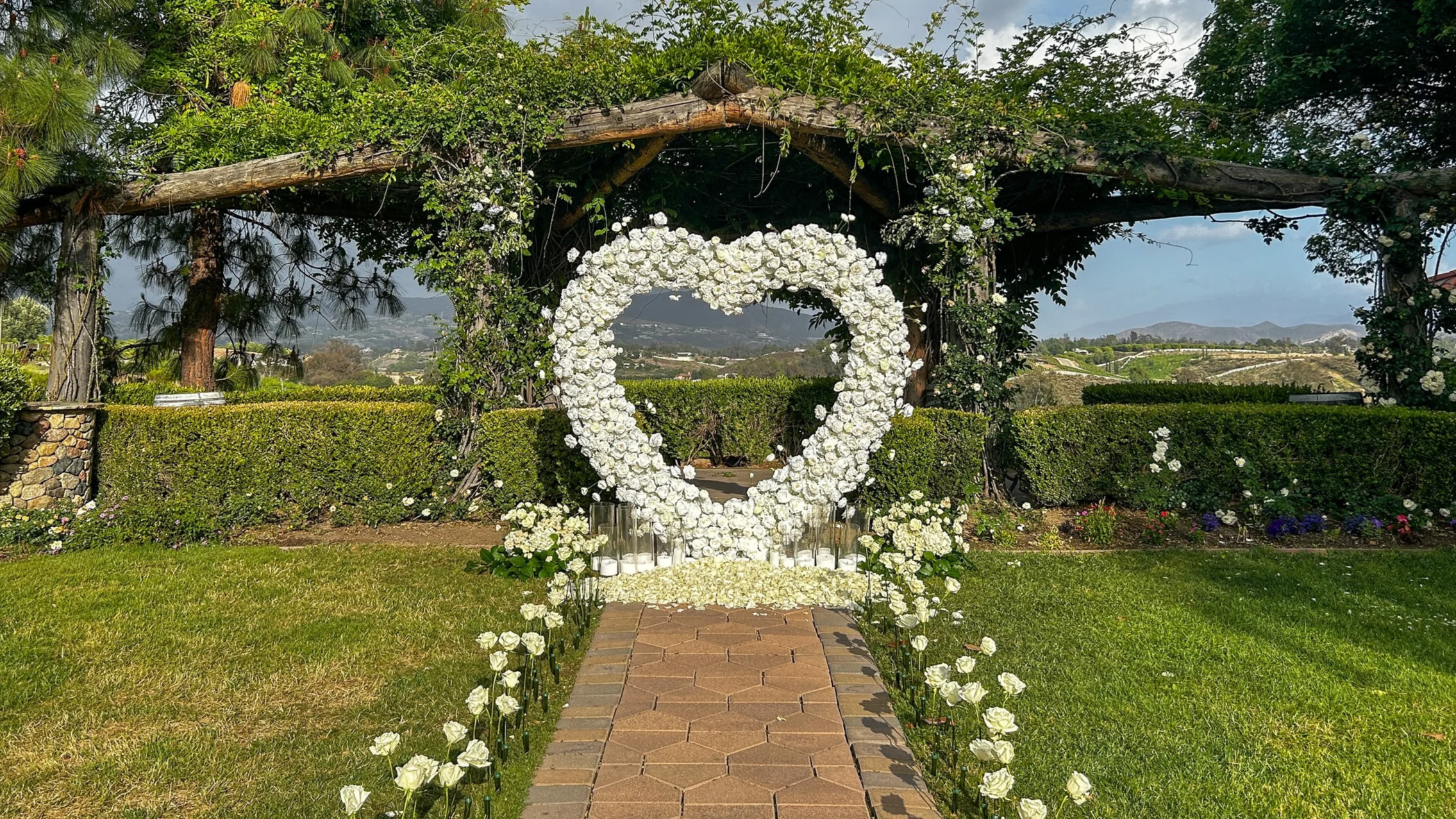 heart arch candle light and rose proposal in front of a rose arbor overlooking vineyards