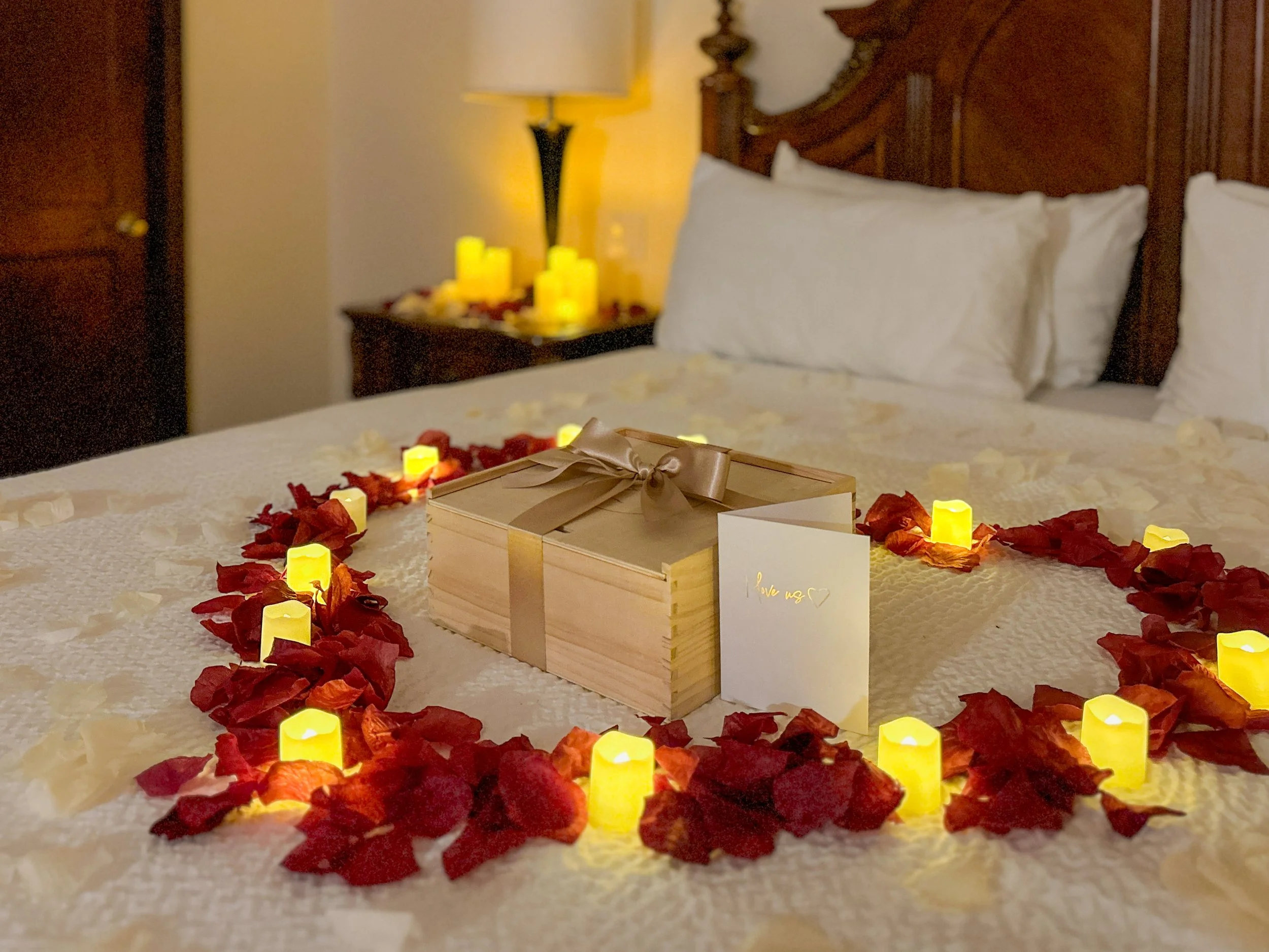 a floor covererd with rose petals and tealight candles leading to a bedroom