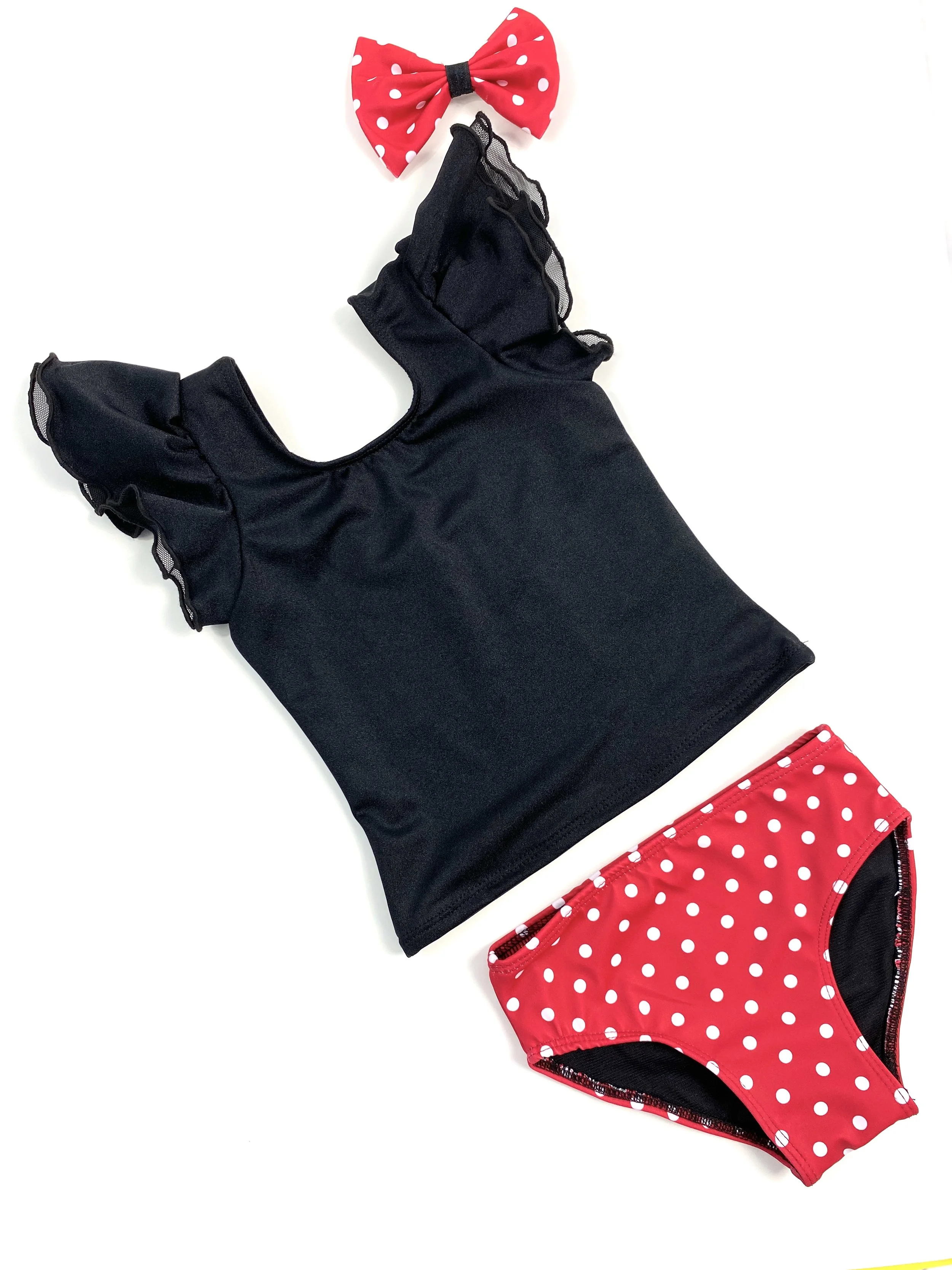 A black sleeveless top with ruffled shoulder straps, red polka dot bikini bottoms, and a matching red polka dot bow hair accessory.