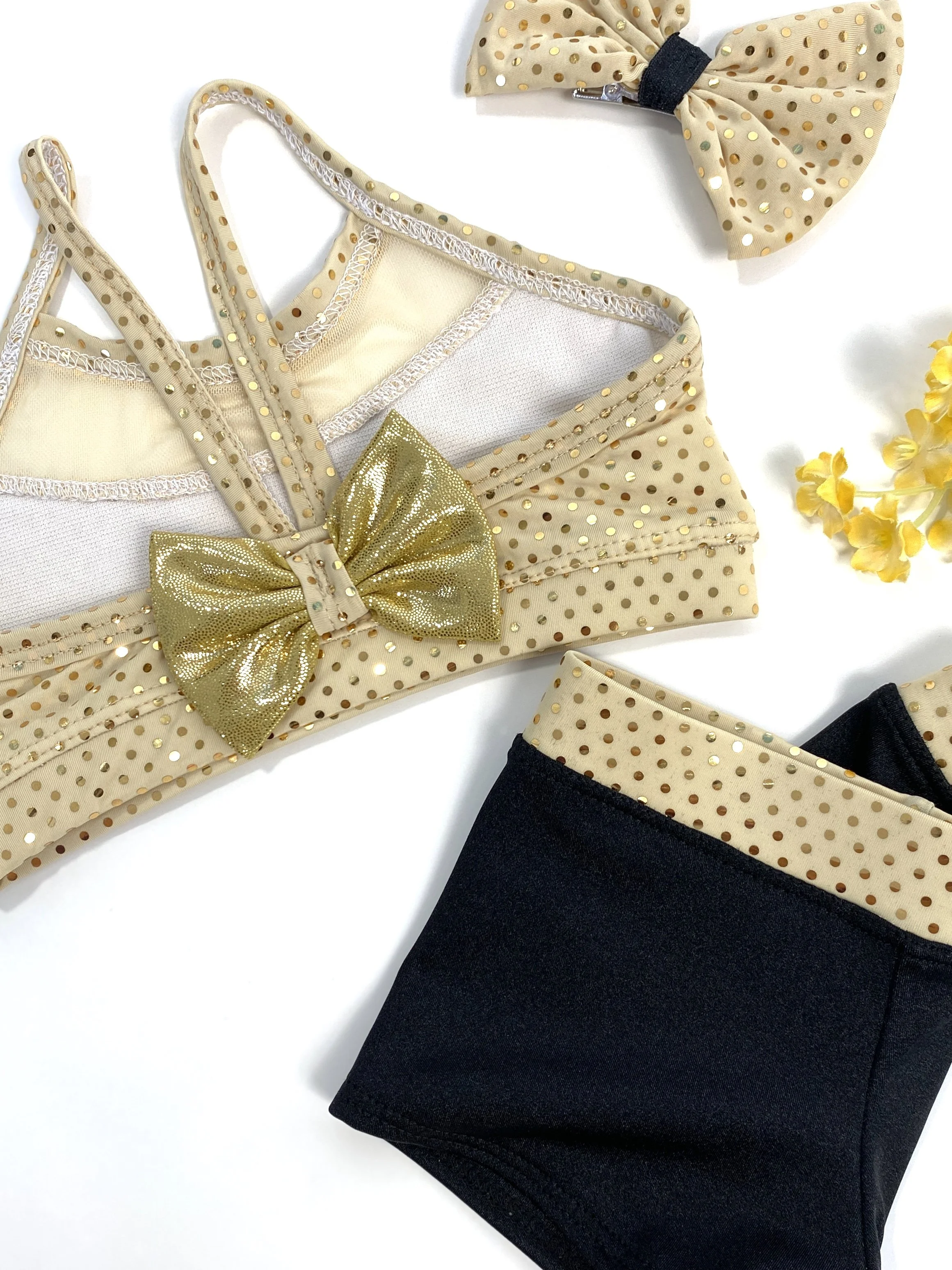 Polka dot clothing set with a gold bow, beige polka dot headband, and black leggings.