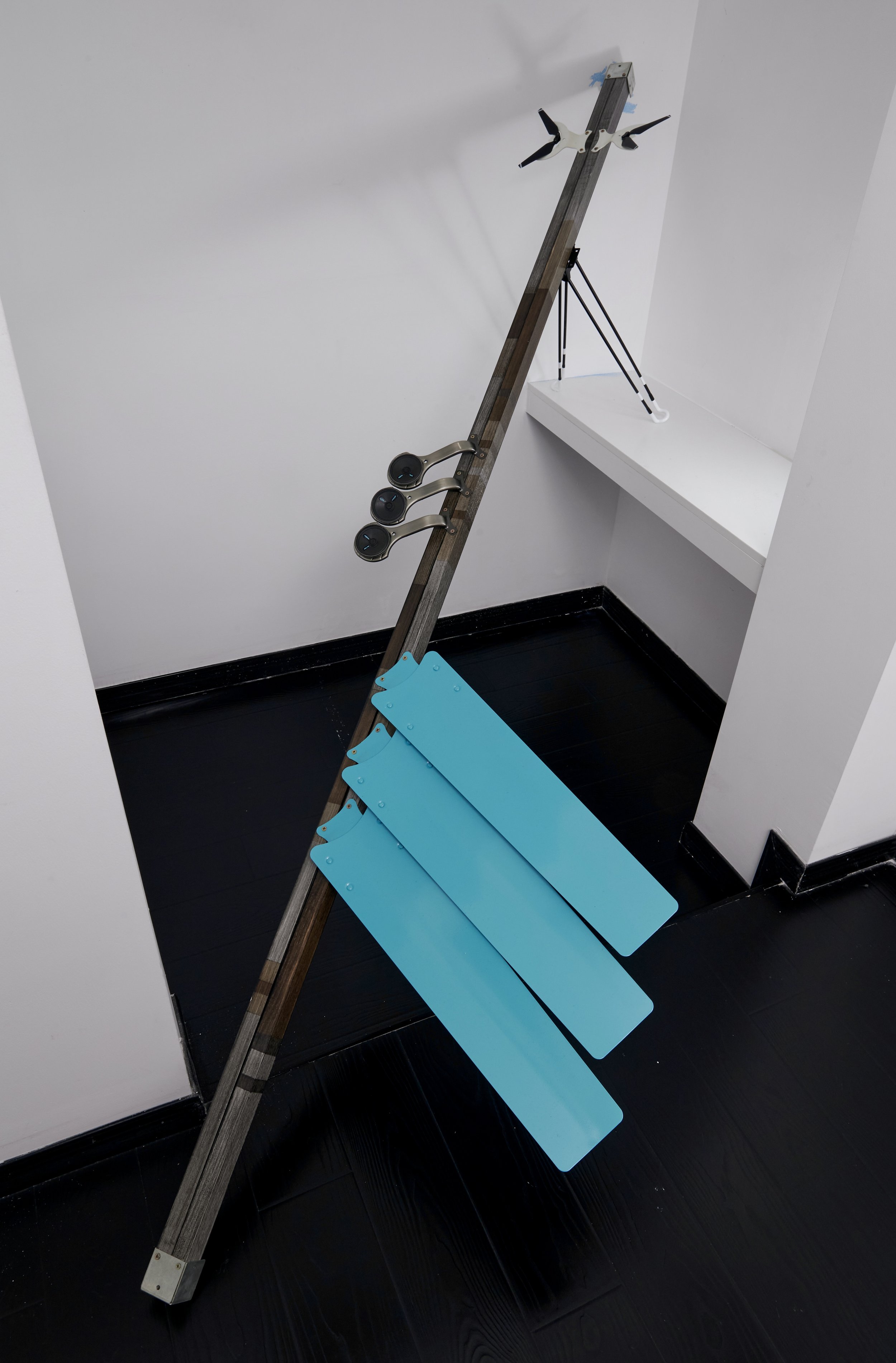 
Benchmark, 2024-2025, 300x54x52cm,Stained Wood, End Clamps, Celling Fan Blades, Hardware, Table Legs, Speakers, Drone Propellers and Acrylic Paint
