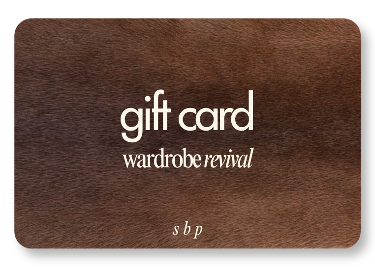 A gift card from Wardrobe Revival with a wood texture background, featuring the words 'gift card' in large font, 'wardrobe revival' below it, and small letters 'sbp' at the bottom.