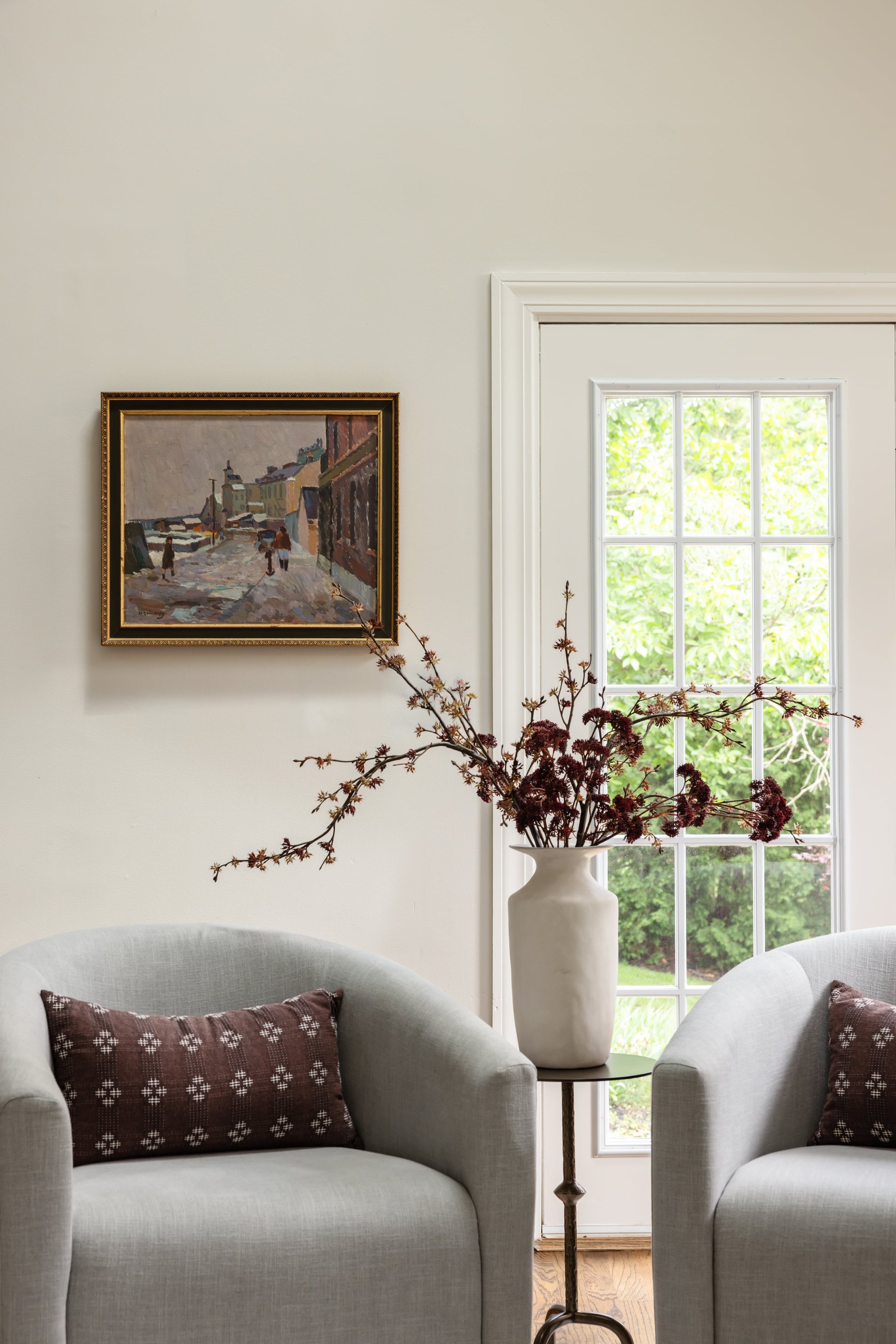 Cozy seating area with upholstered armchairs, patterned pillows and layered accessories.