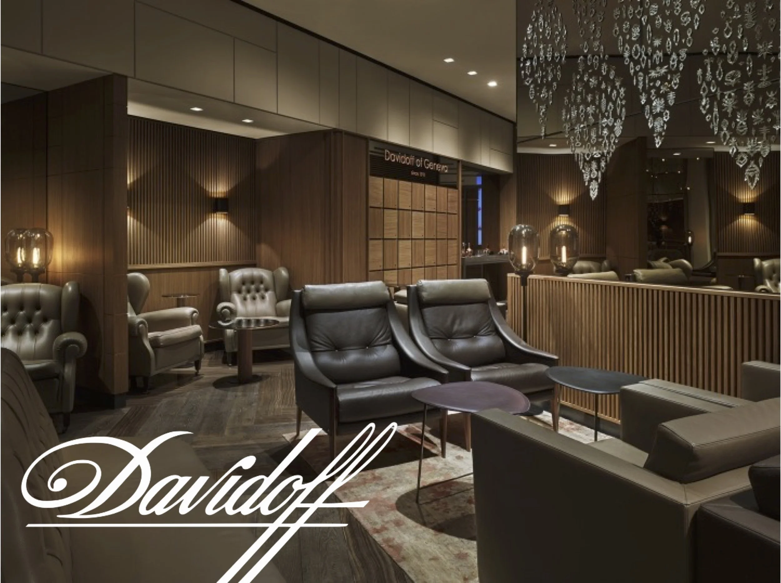 Elegant Davidoff Cigar lounge with leather chairs and wooden wall decor, centerpiece chandelier, and ambient lighting.