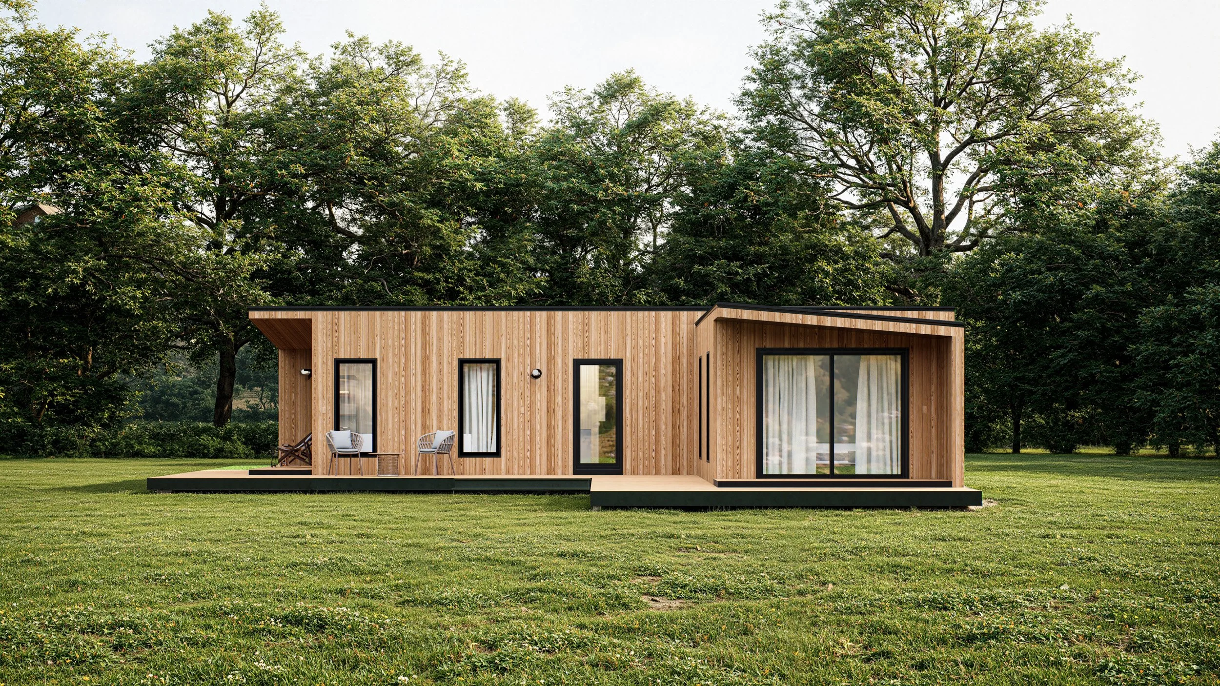 Modern single-story house with wooden exterior, large glass sliding doors, and outdoor seating on a deck, surrounded by green trees and grass.