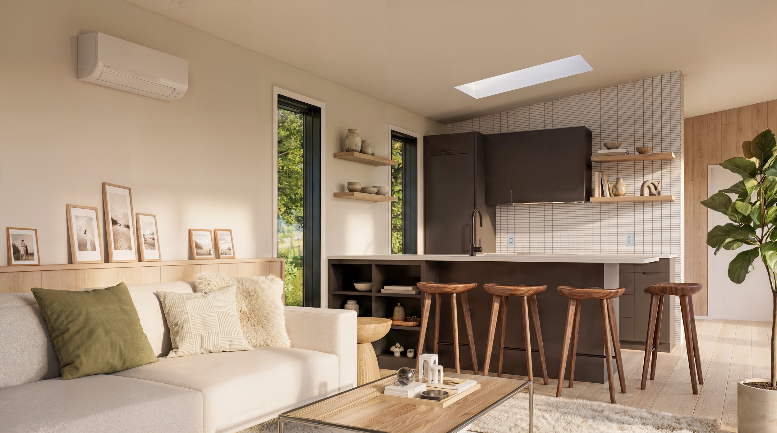 Modern living room with beige sofa, green and beige pillows, wooden picture frames on the wall, open kitchen with black cabinets, bar stools, and a large potted plant.