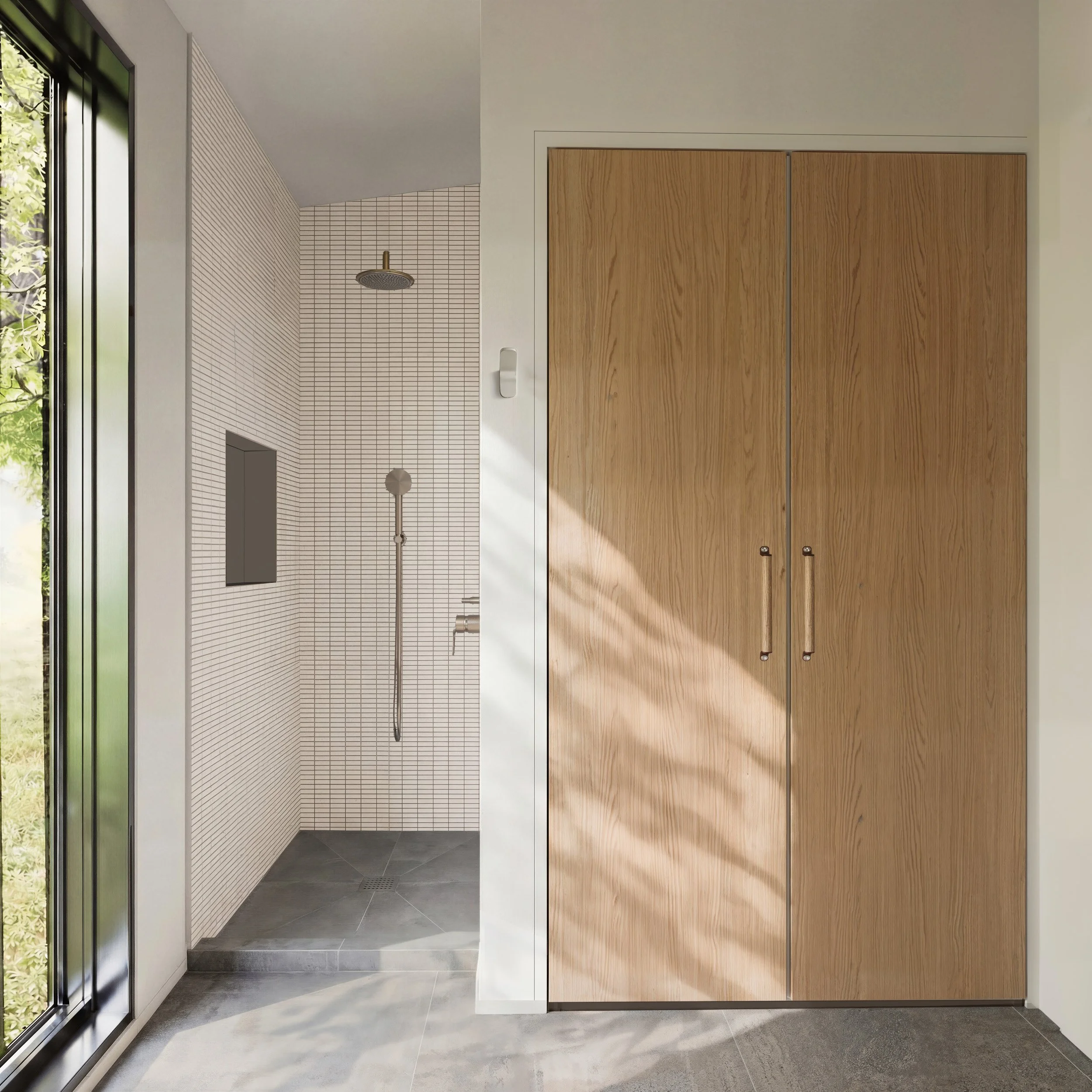 Modern shower area with white tiled wall, ceiling-mounted showerhead, handheld shower wand, small niche, and gray tiled floor, next to wooden closet doors, with natural light coming through a glass door.