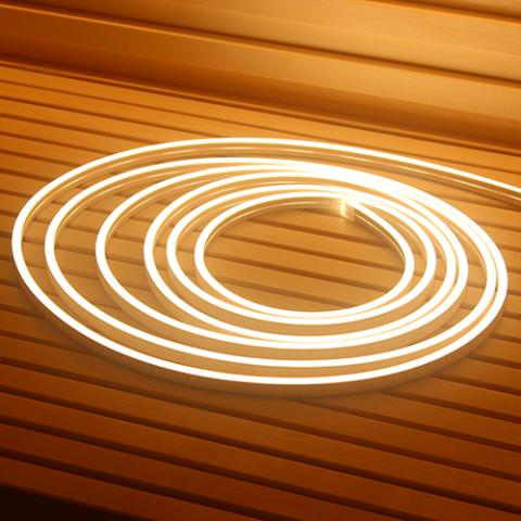 Three glowing neon rings on a wooden surface with wooden slats on the wall behind.