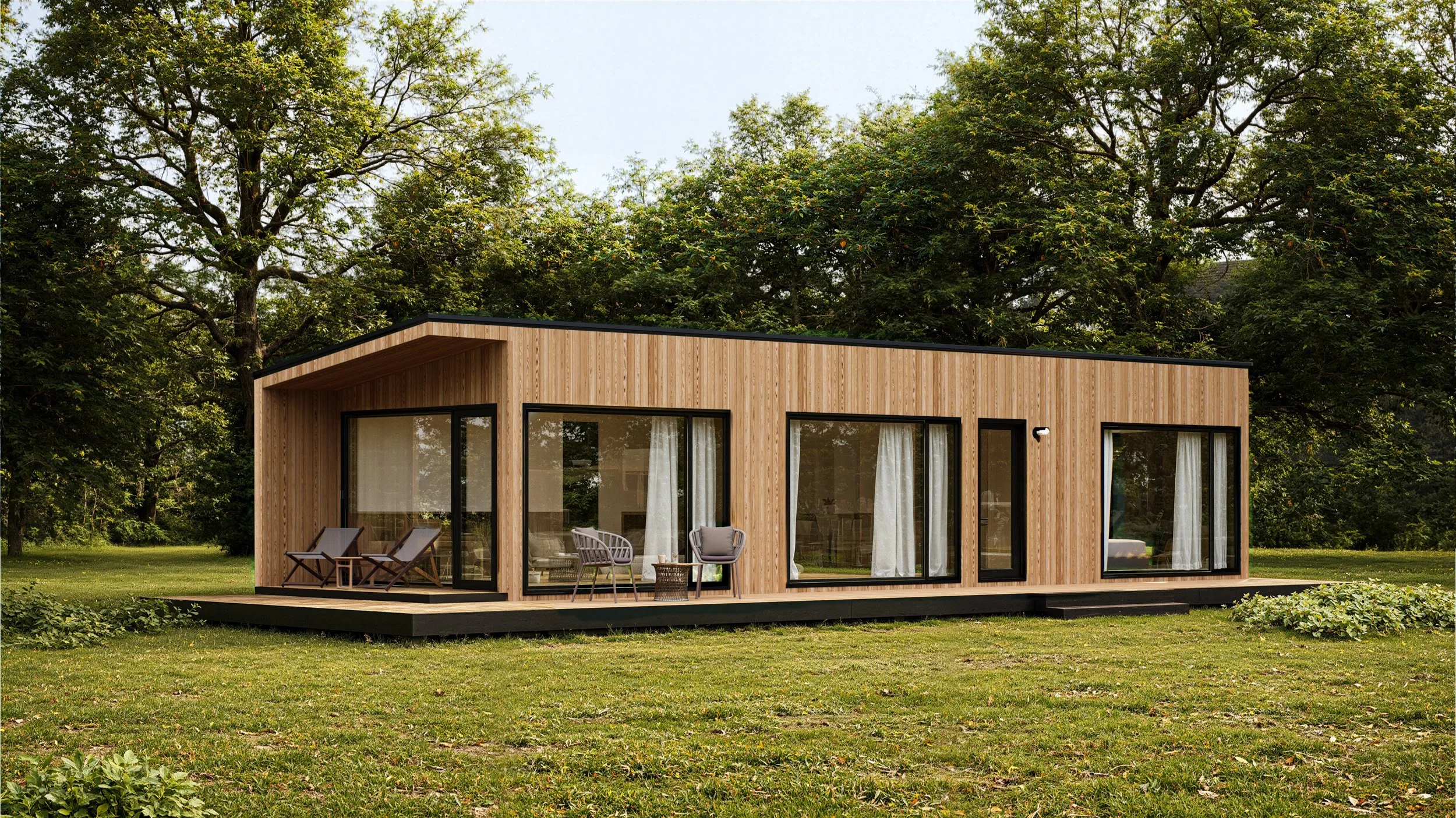 Modern tiny house with wooden exterior, large glass doors and windows, situated on a grassy lawn surrounded by trees.