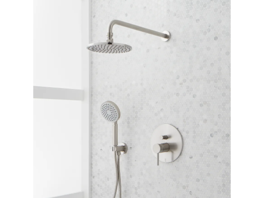 Modern shower with a rain showerhead and handheld shower attachment on a white mosaic tile wall.
