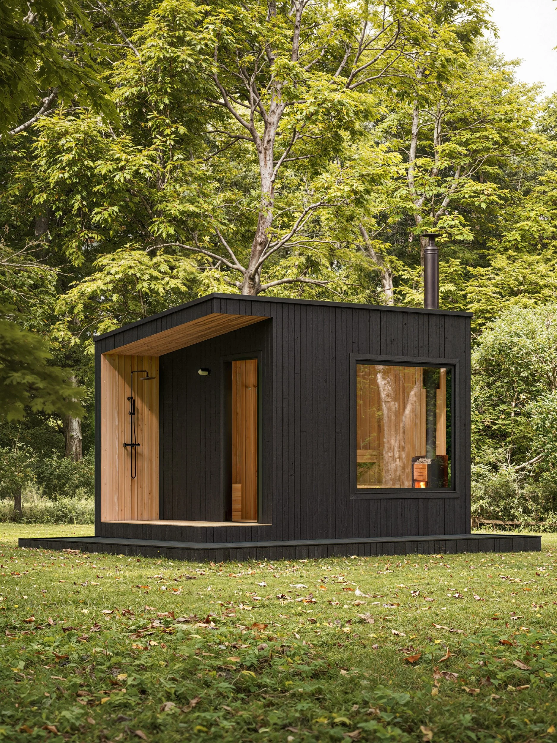Small modern tiny house with black exterior and wooden accents, situated on a grassy lawn surrounded by trees.