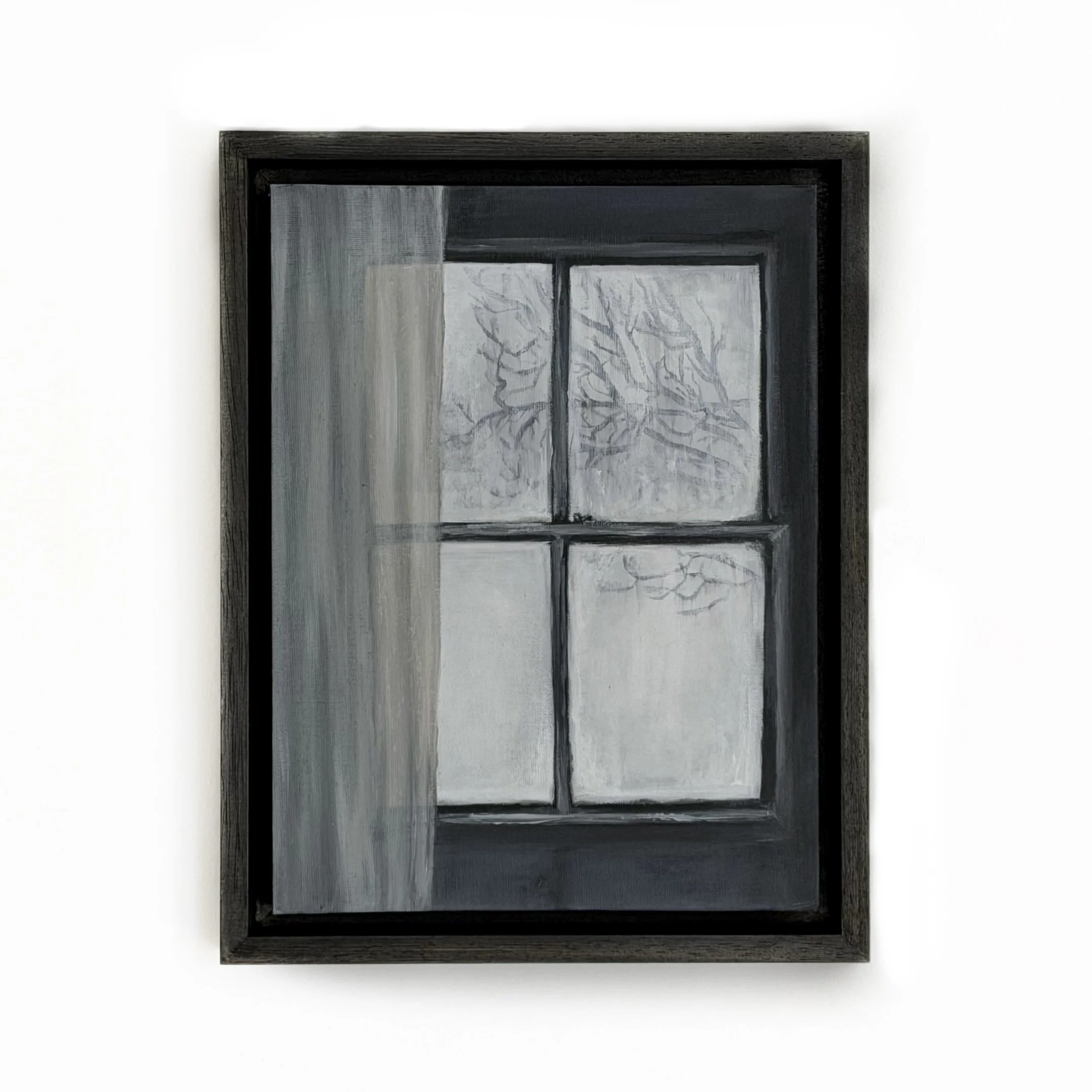 A black-framed window with two panes, featuring a frosted glass with a tree pattern, set against a white wall.