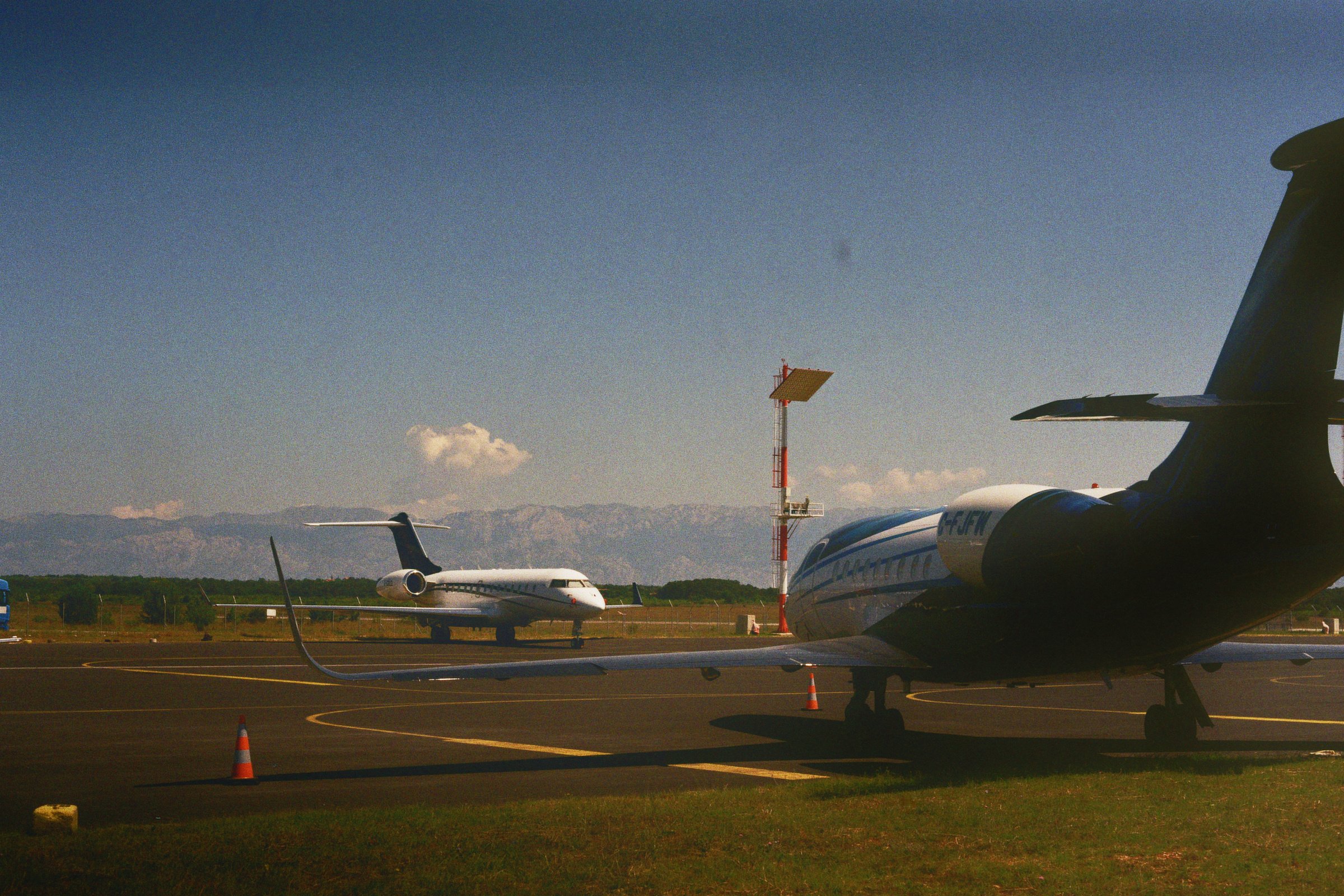 Private Flugzeuge auf einem Flughafen in Zadar, Kroatien, mit Bergen in der Ferne.