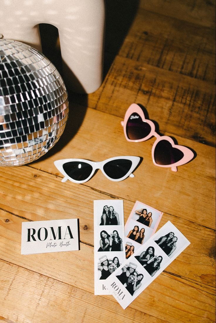 Lunettes de soleil chic et photos de cabine photo sur table en bois.