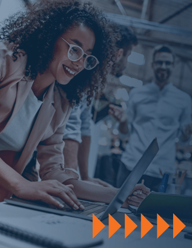 Smiling professional collaborating on a laptop, symbolizing the energy and connection created by social learning.