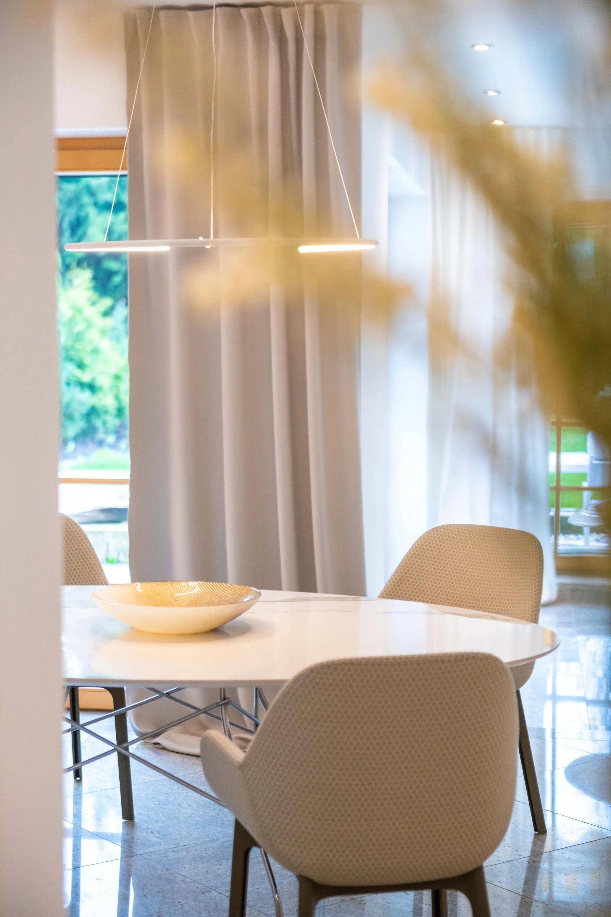 homestaging Foto eines Essbereichs mit runden Designertisch mit Marmorplatte und Kartellstühle in beige