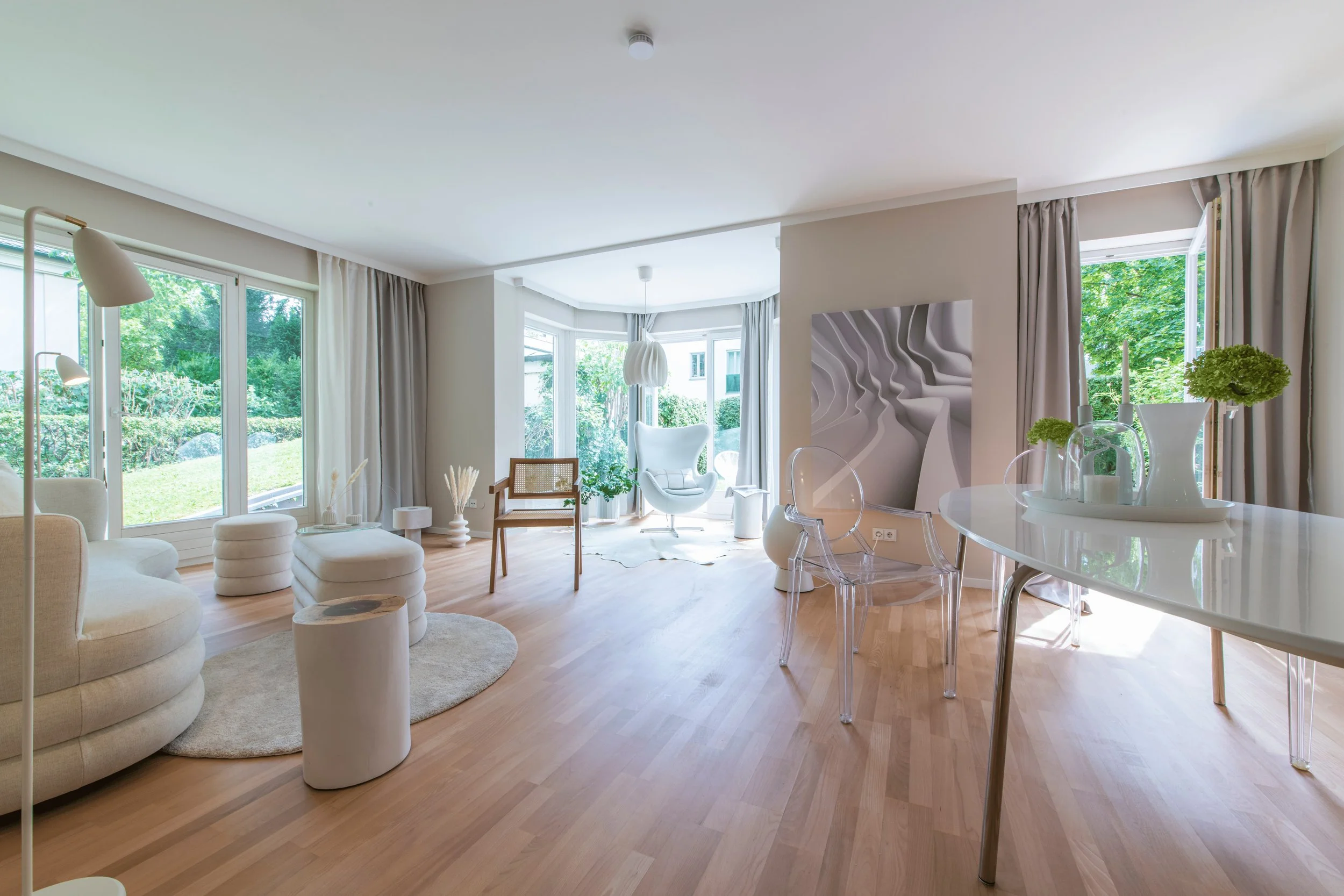 Offener Wohnbereich mit großen Fensterflächen und Blick ins Grüne, professionelles Home Staging für lichtdurchflutete Räume